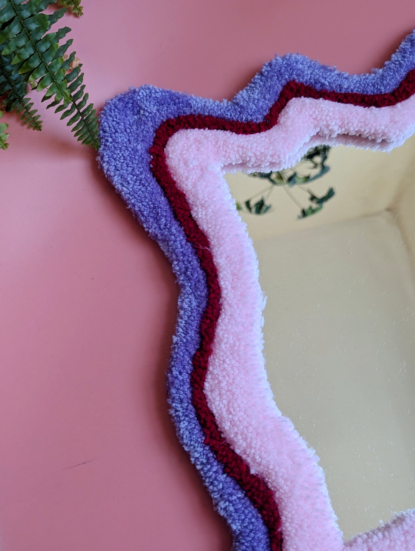 Purple, red and pink coloured wavy pattern tufted yarn mirror