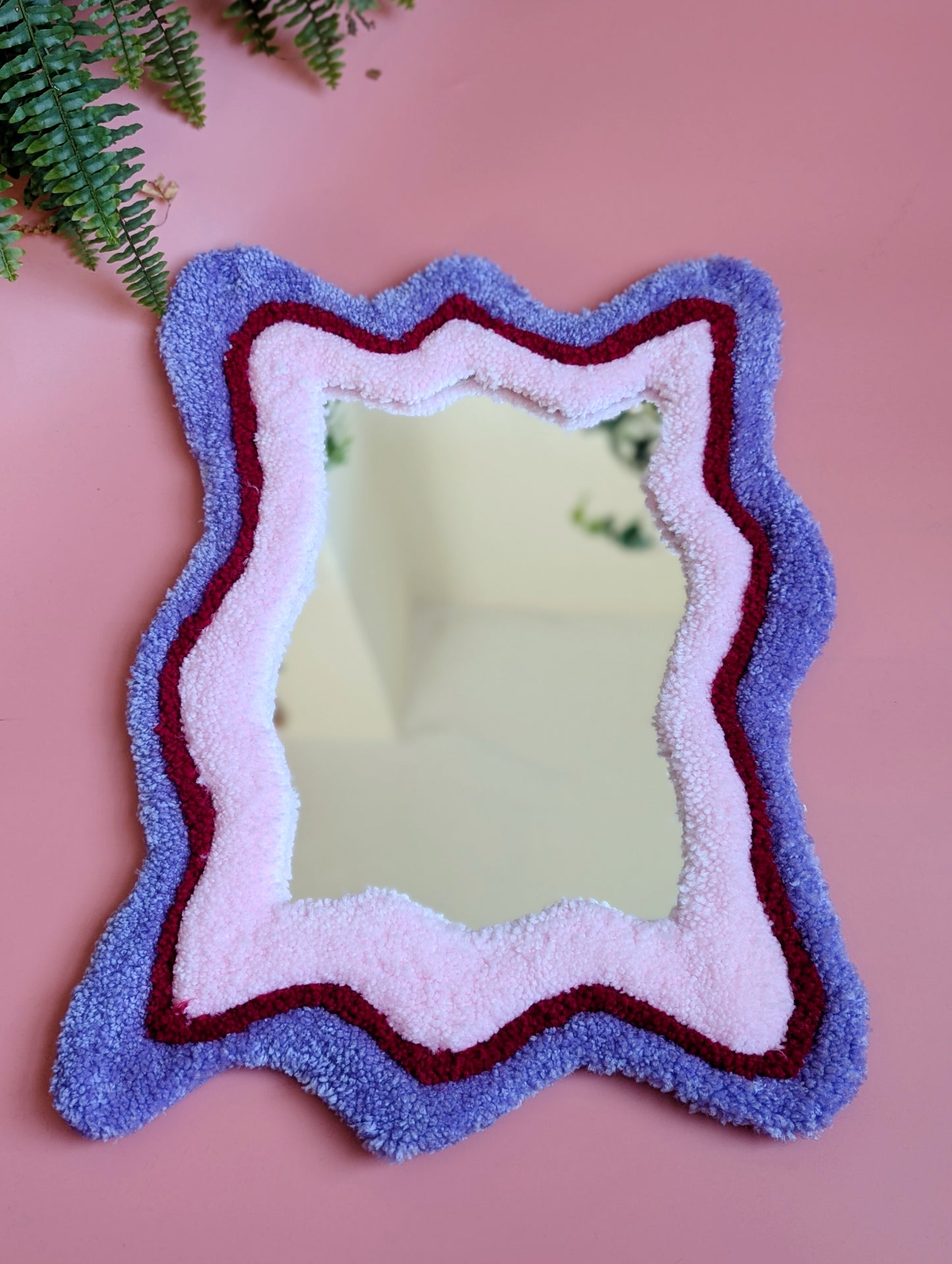 Purple, red and pink coloured wavy pattern tufted yarn mirror