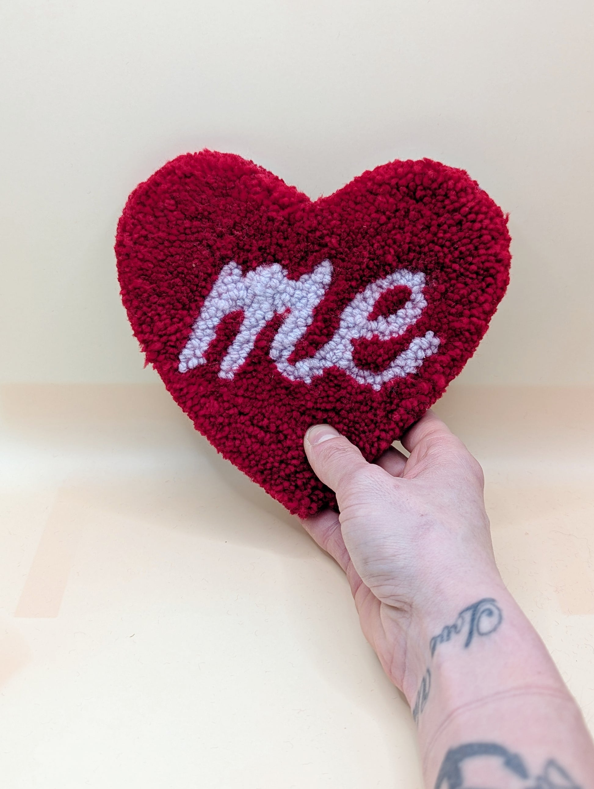 Soft tufted red and purple heart shaped mini rug/coaster with self love slogan