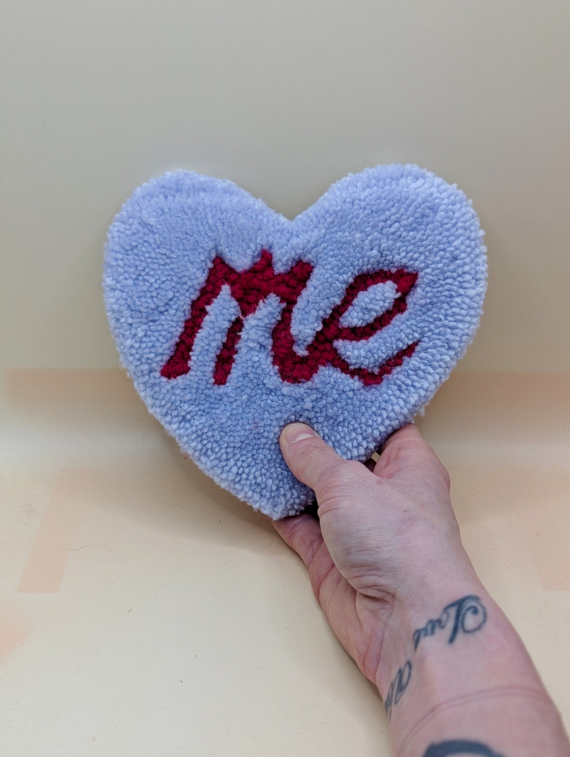 Soft tufted purple and red heart shaped mini rug/coaster with self love slogan