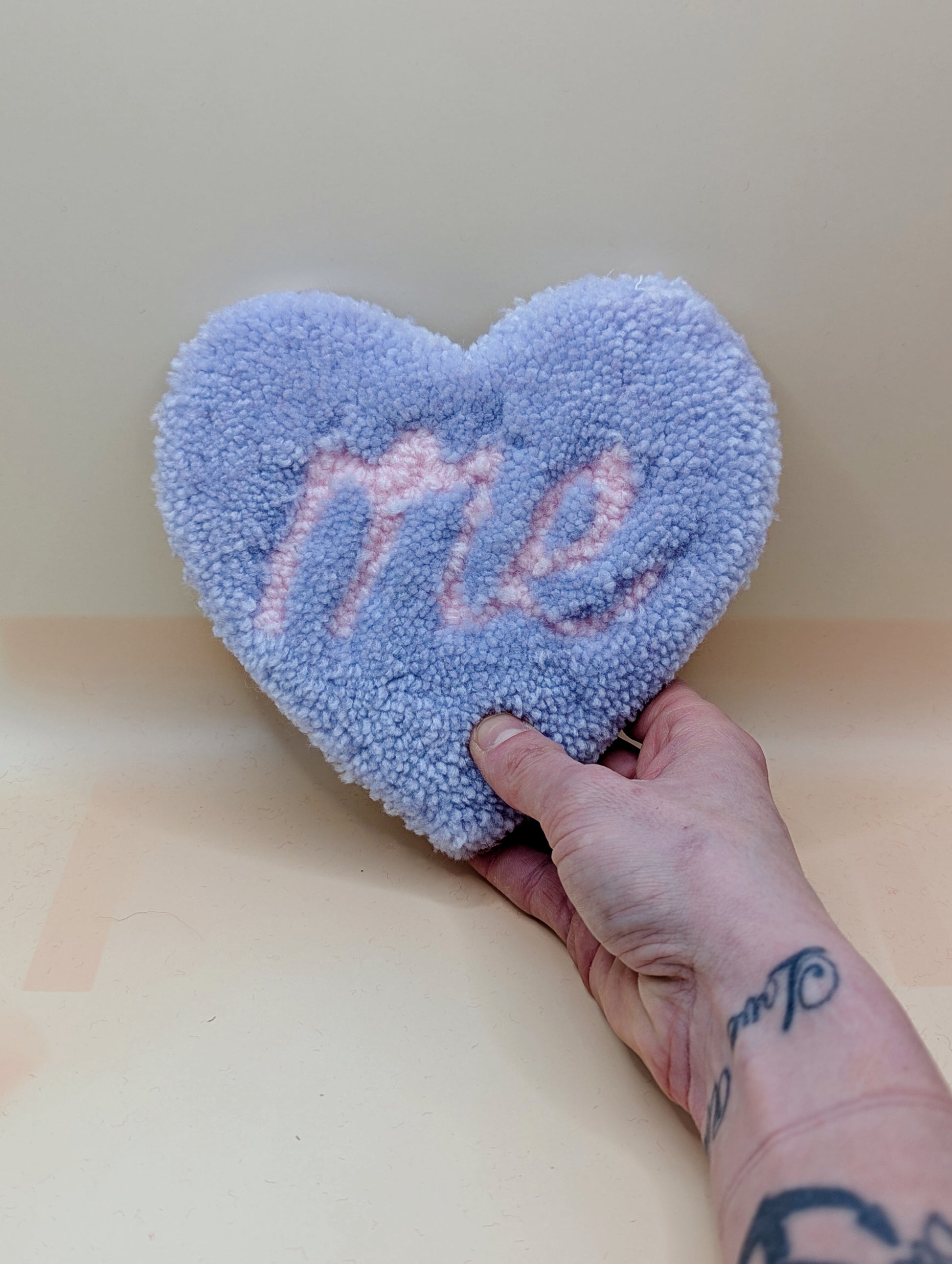 Soft tufted purple and pink heart shaped mini rug/coaster with self love slogan