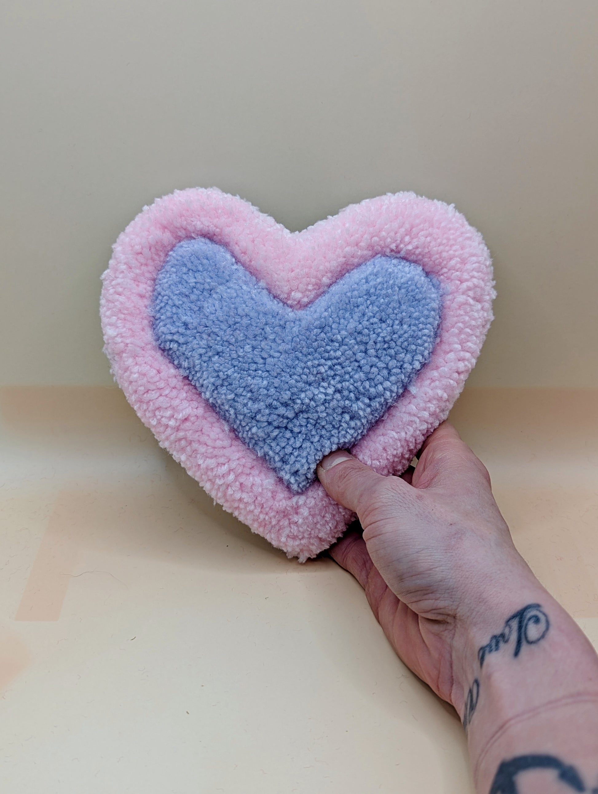 Soft tufted pink and purple heart shaped mini rug/coaster 