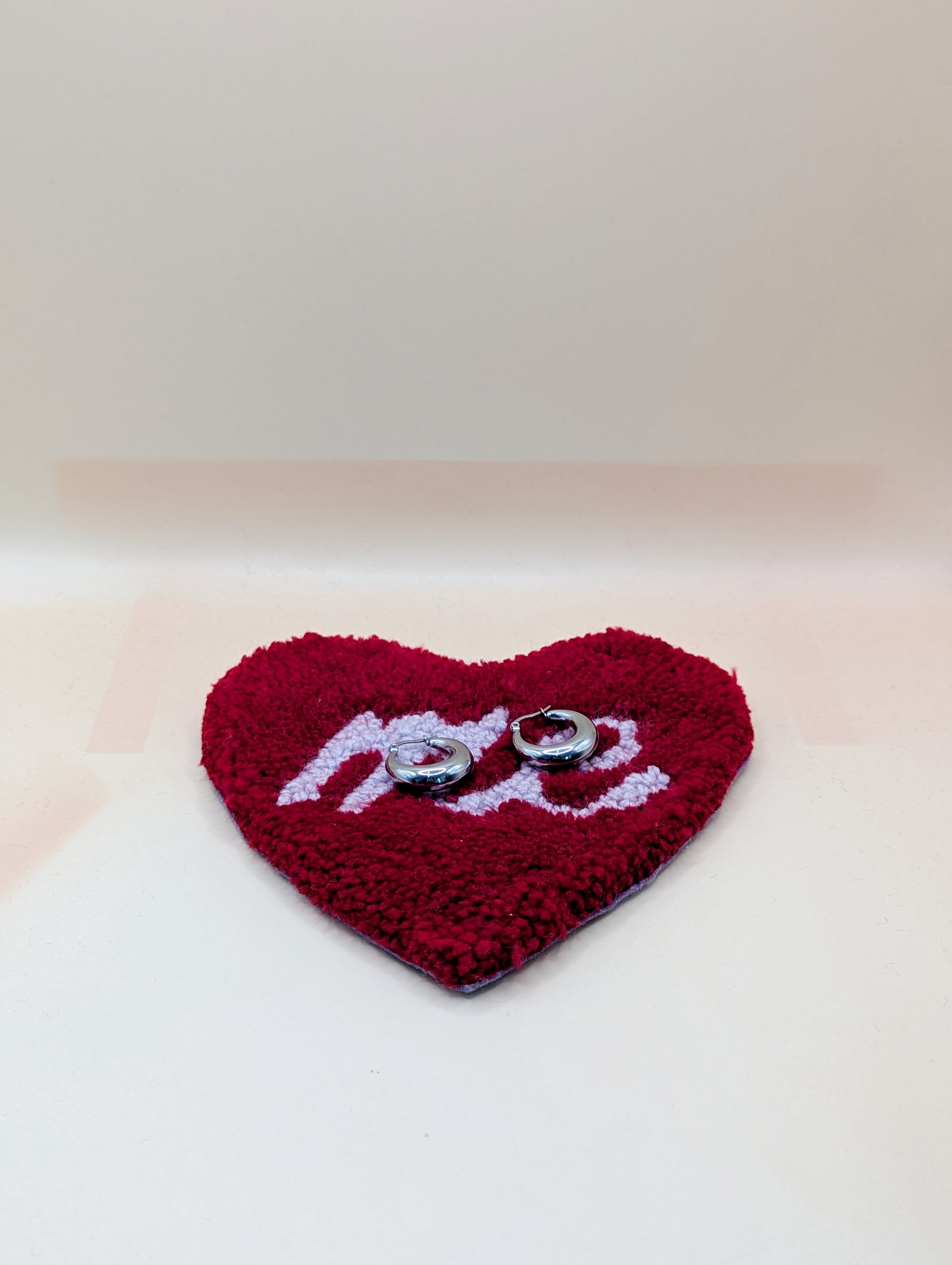 Soft tufted red and purple heart shaped mini rug/coaster with self love slogan