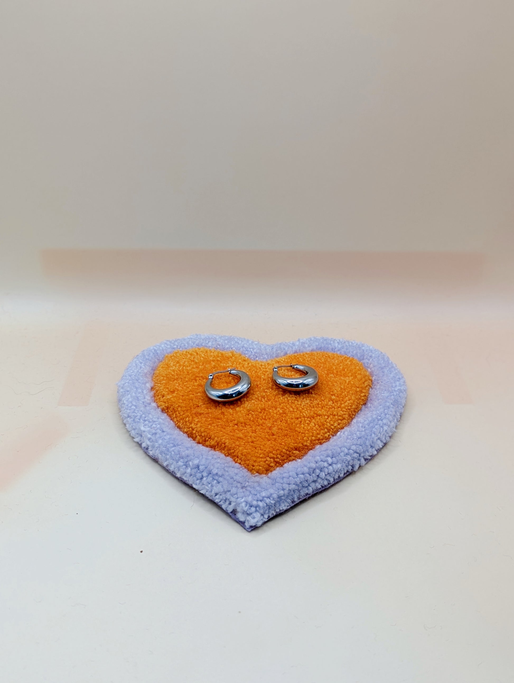 Soft tufted purple and orange heart shaped mini rug/coaster 