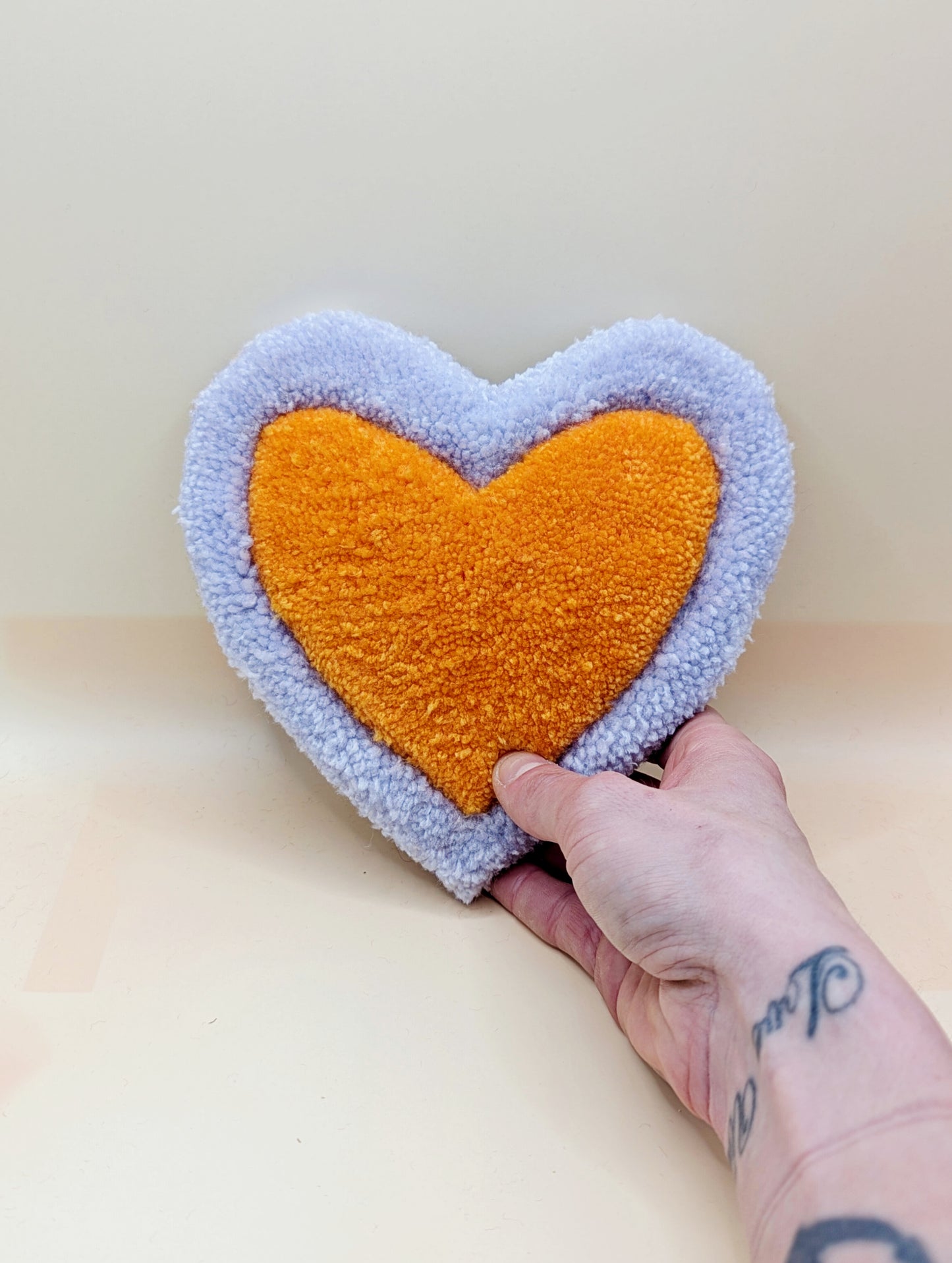 Soft tufted purple and orange heart shaped mini rug/coaster 
