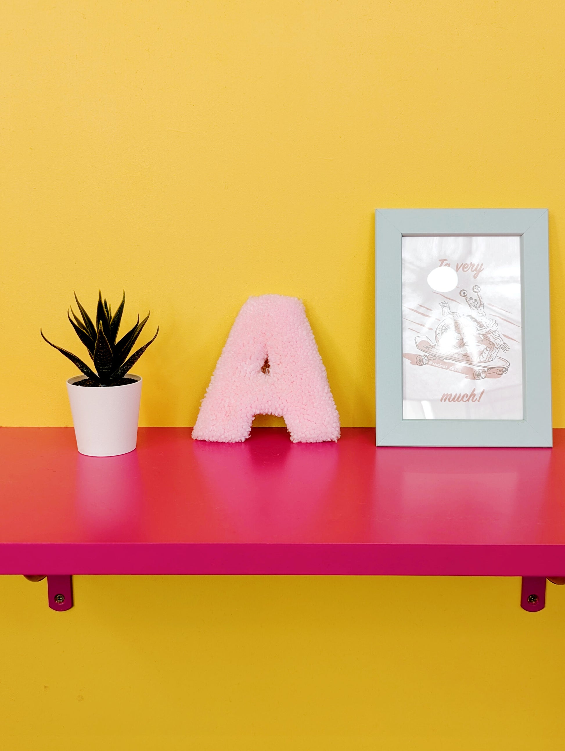 Soft tufted pink letter A with metal hook for easy hanging