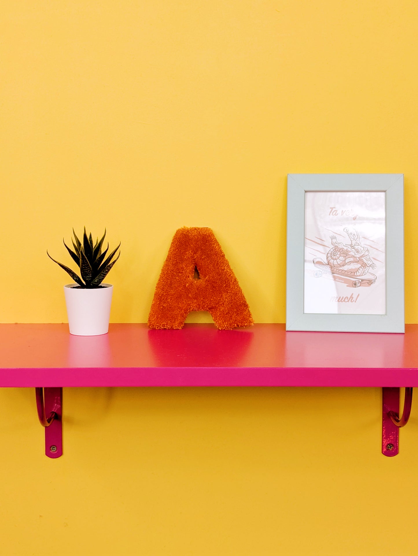 Soft tufted orange letter A with metal hook for easy hanging