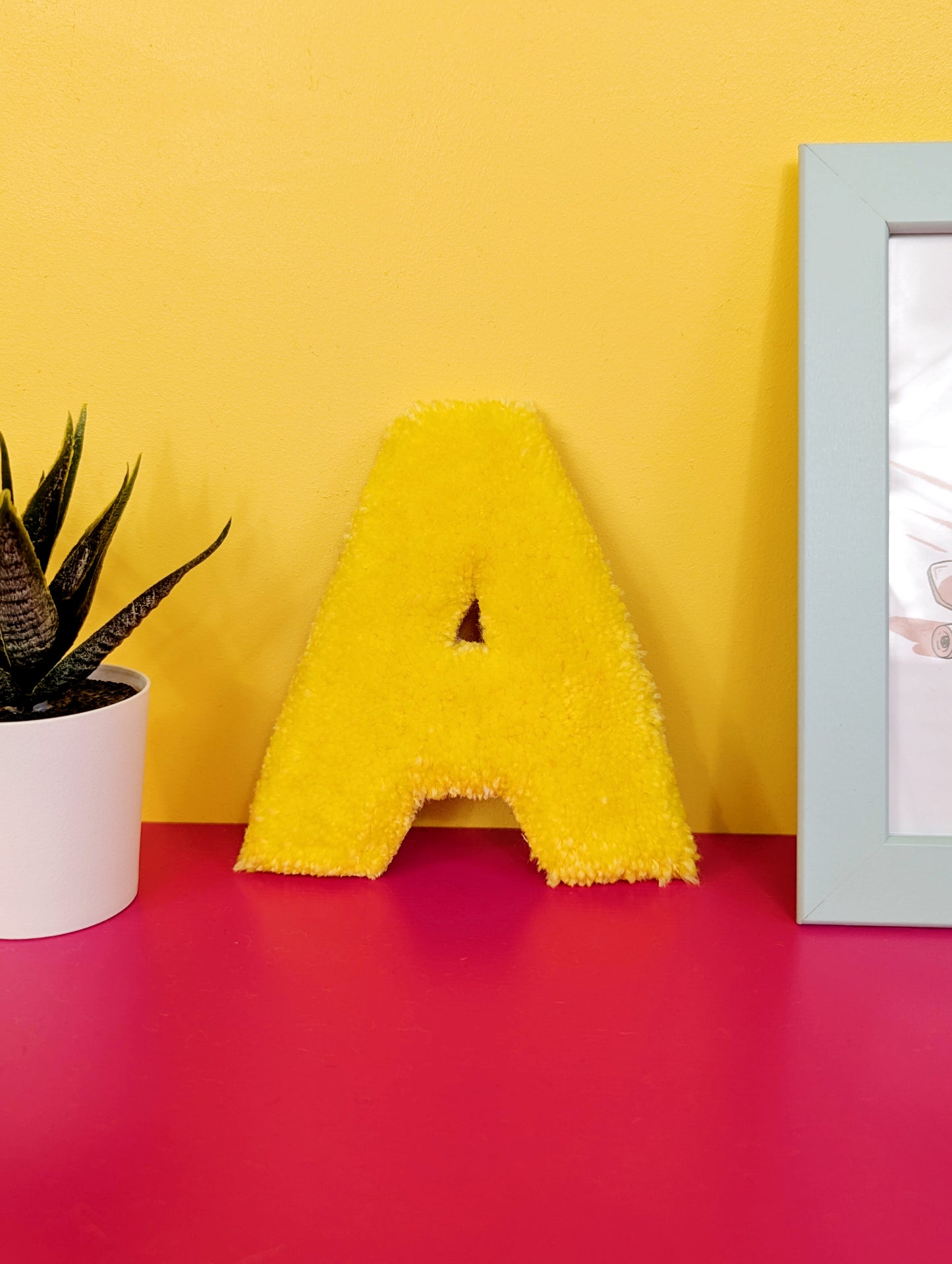 Soft tufted yellow letter A with metal hook for easy hanging