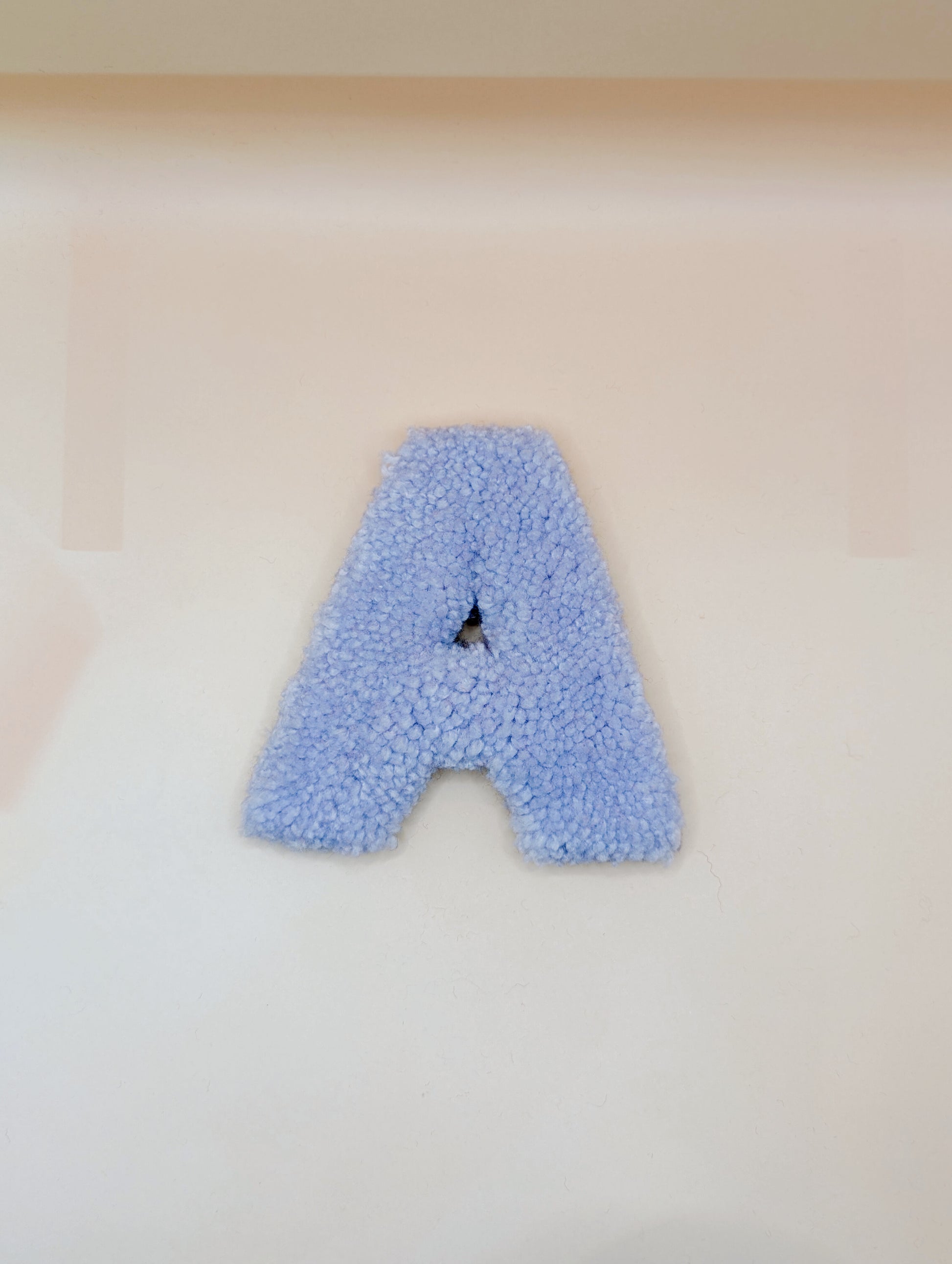 Soft tufted light purple letter A with metal hook for easy hanging