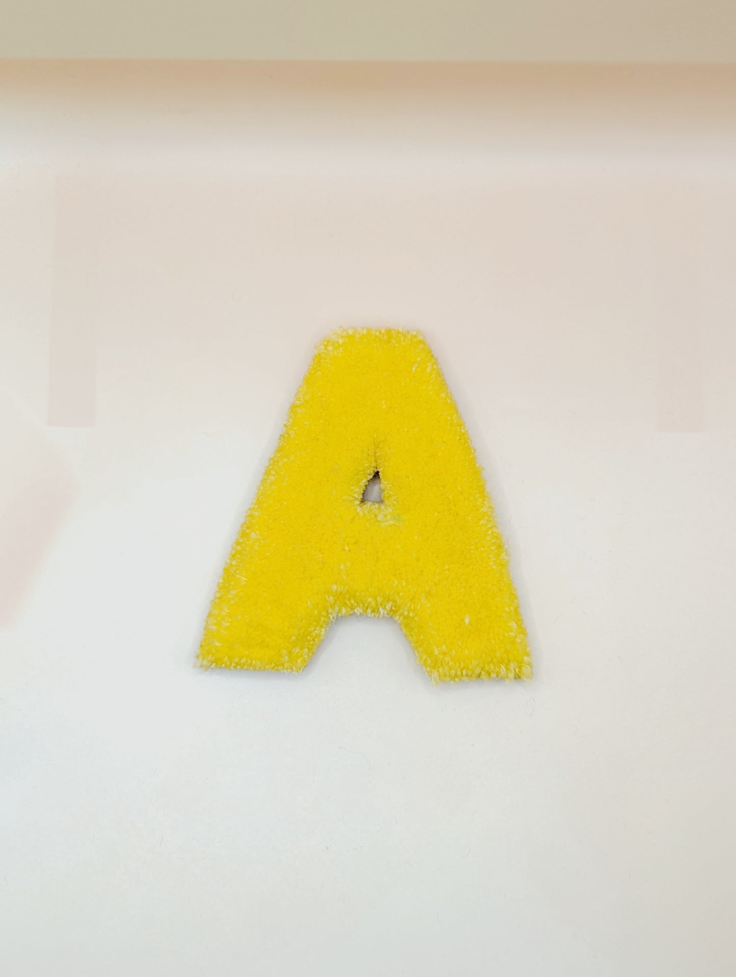 Soft tufted yellow letter A with metal hook for easy hanging