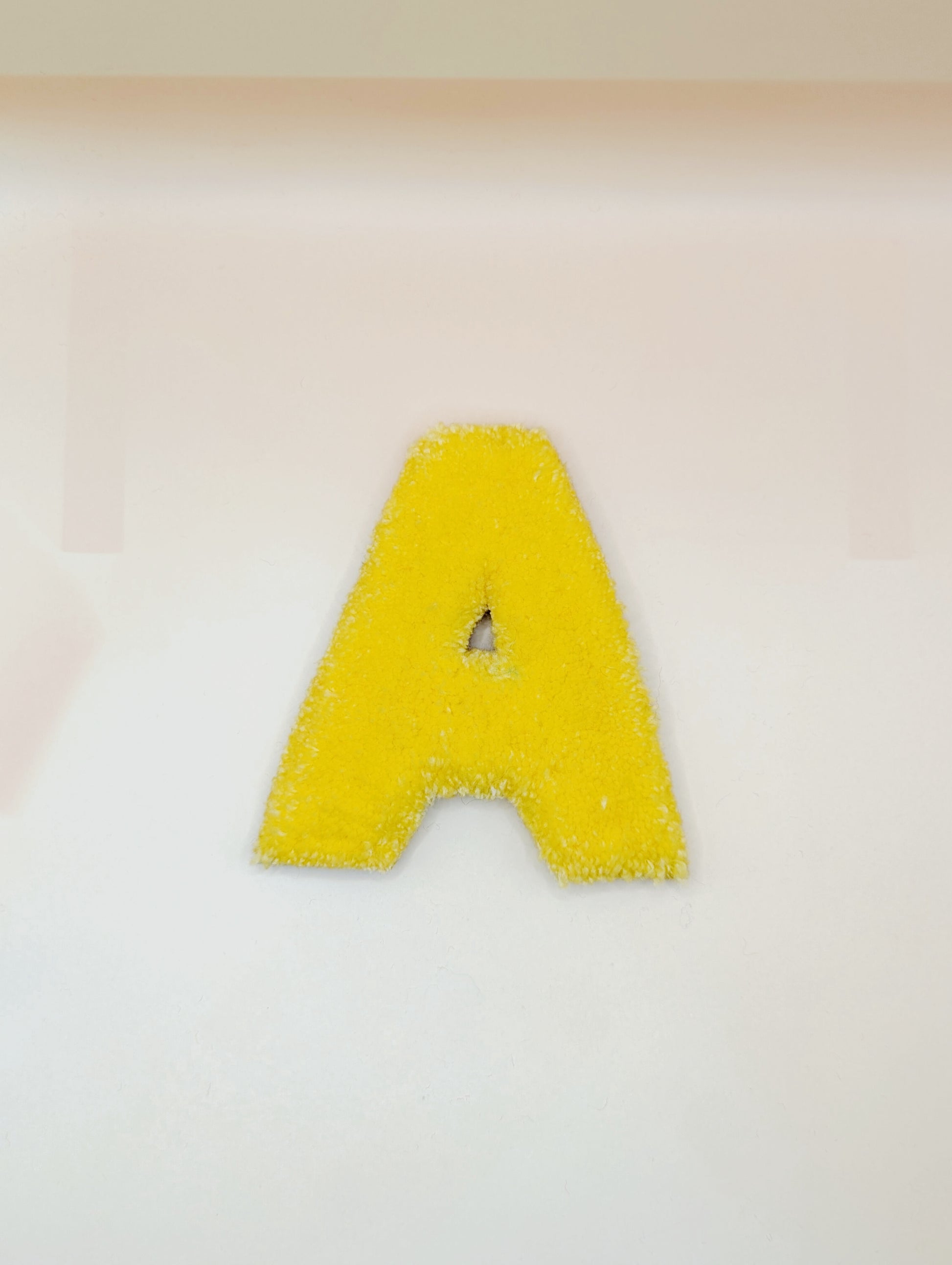 Soft tufted yellow letter A with metal hook for easy hanging