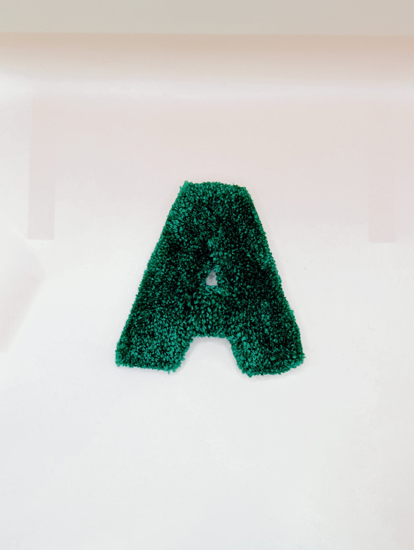 Soft tufted green letter A with metal hook for easy hanging