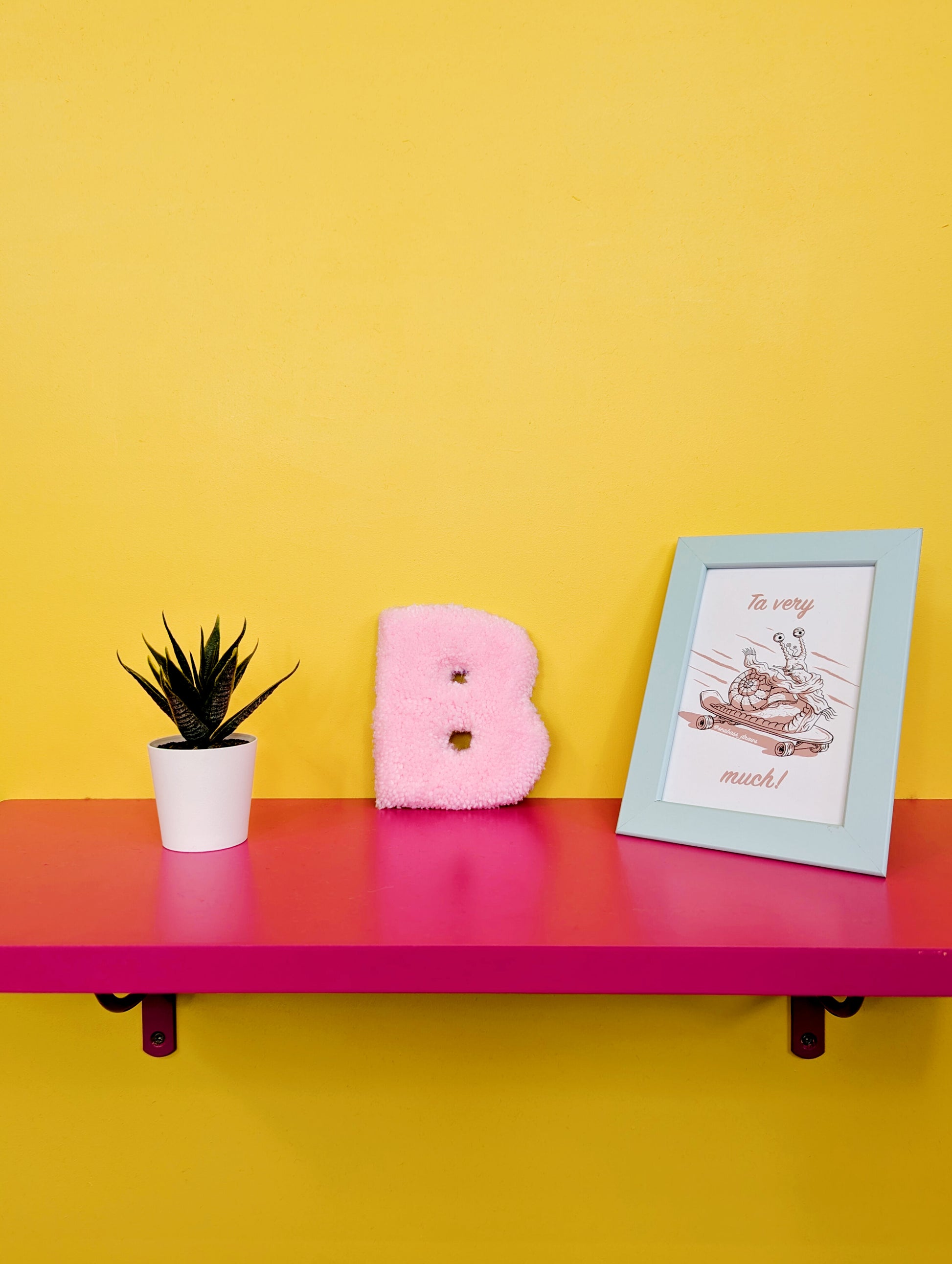 Soft tufted pink letter B with metal hook for easy hanging