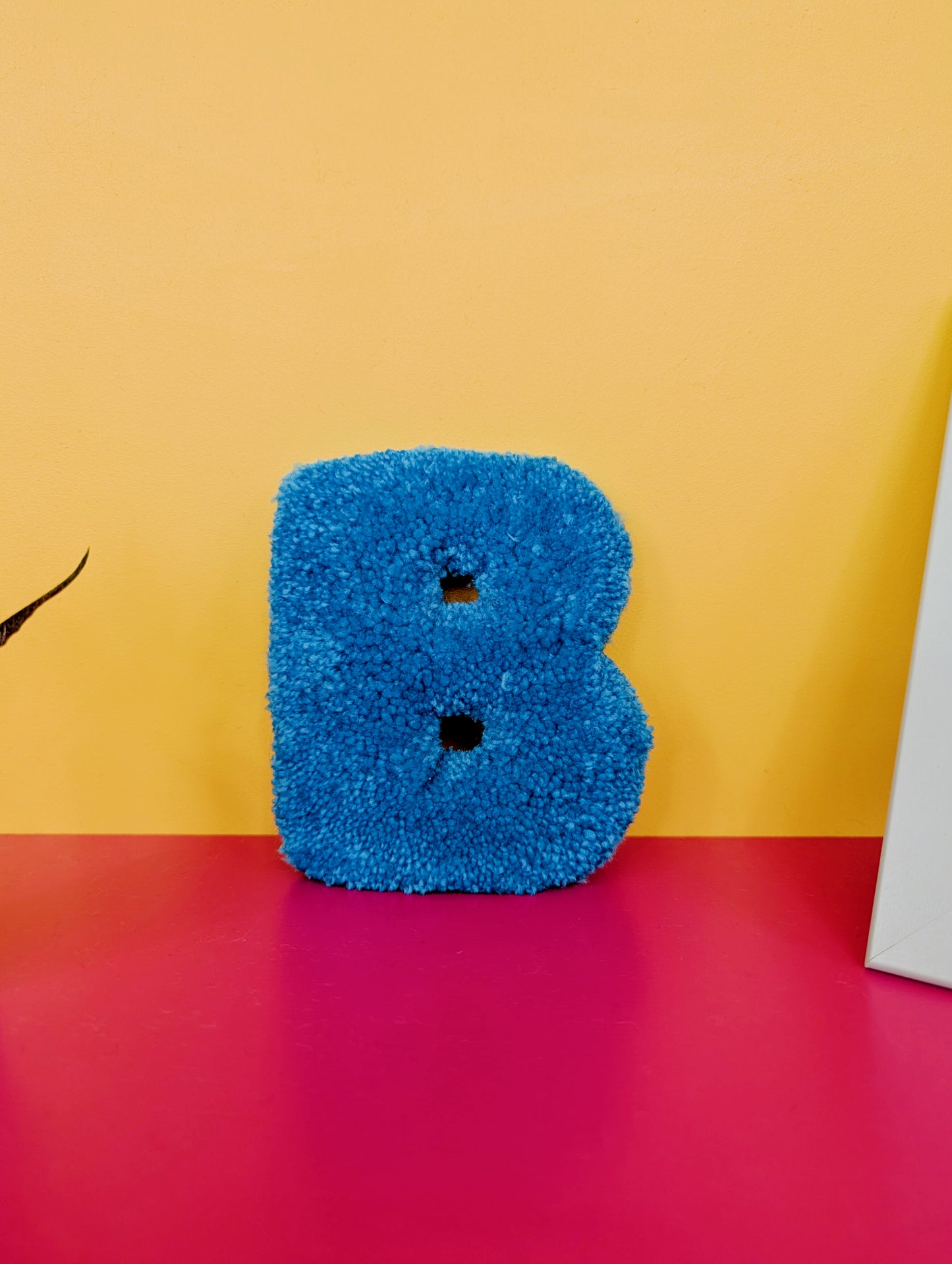 Soft tufted blue letter B with metal hook for easy hanging