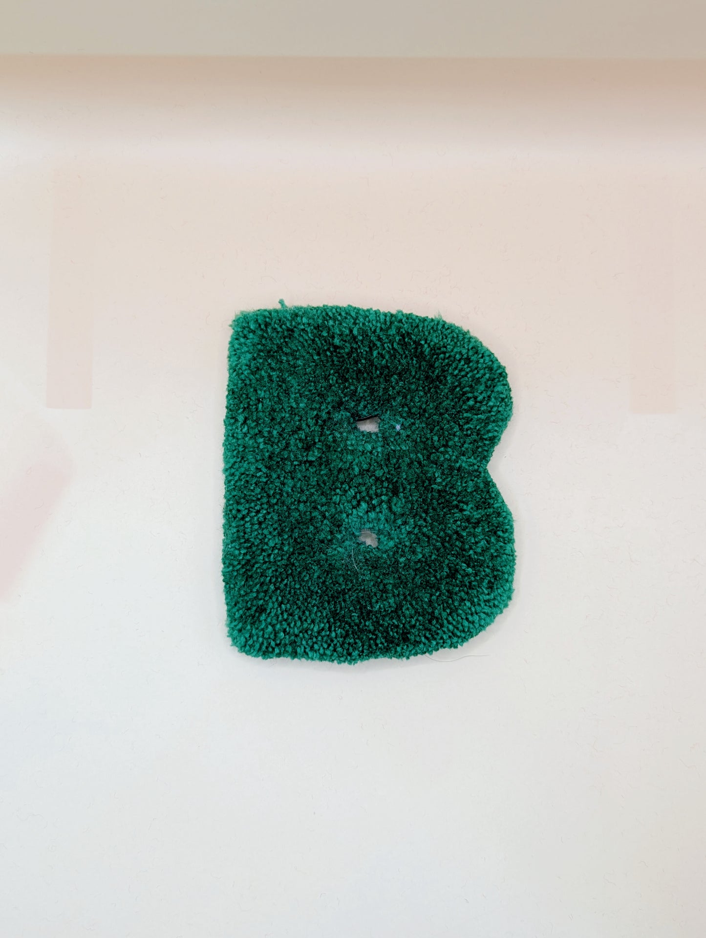 Soft tufted green letter B with metal hook for easy hanging