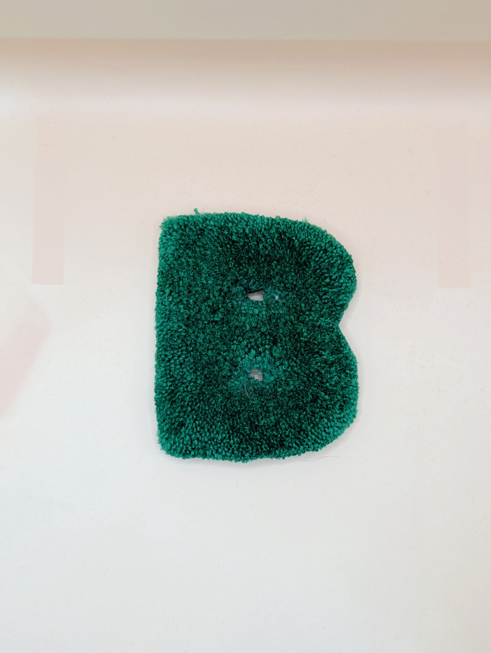 Soft tufted green letter B with metal hook for easy hanging