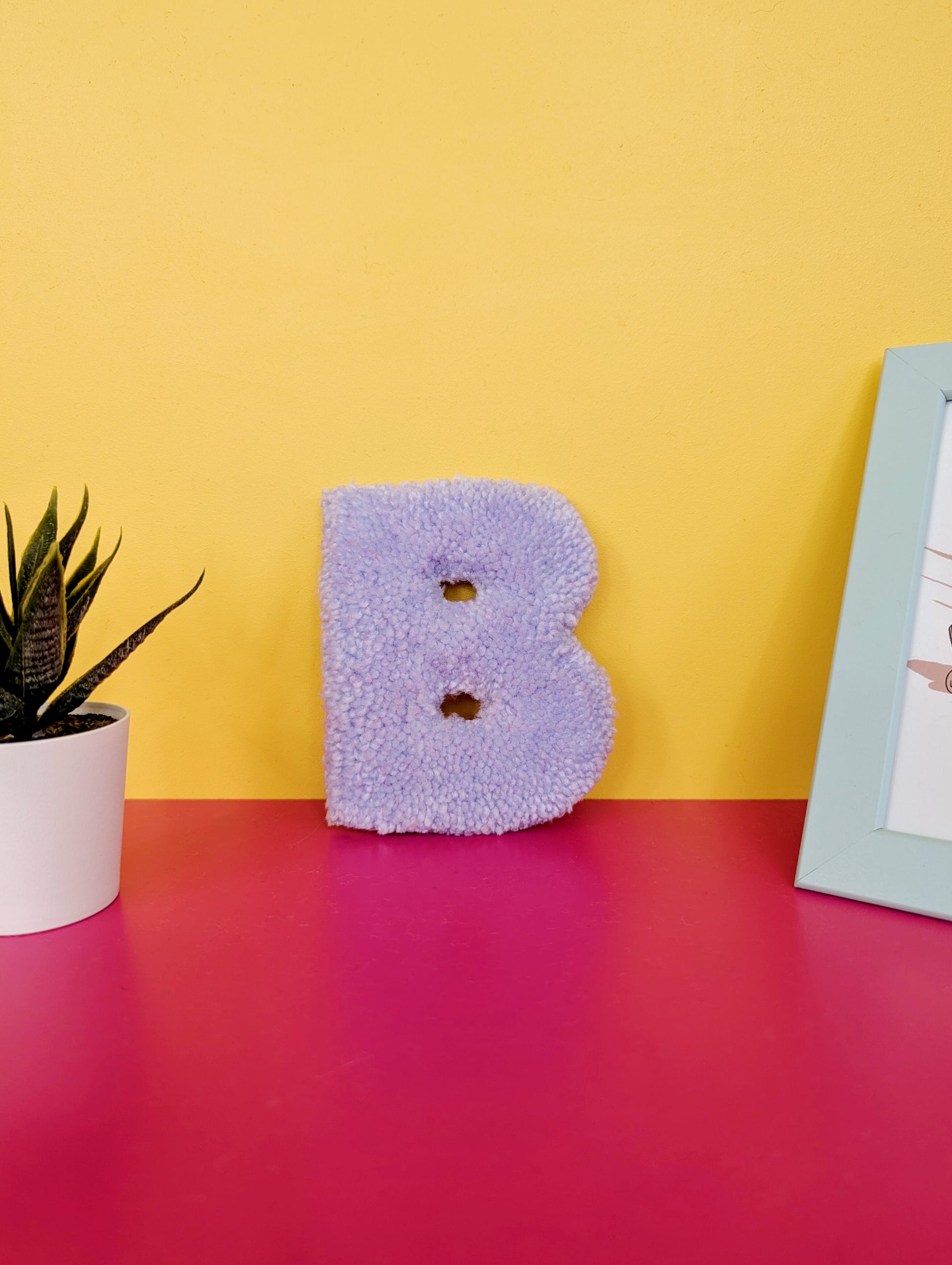 Soft tufted purple letter B with metal hook for easy hanging