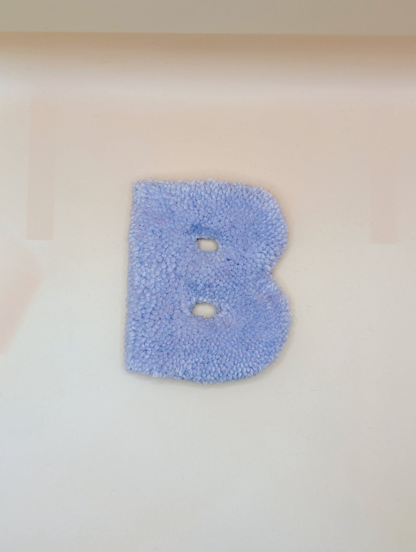 Soft tufted purple letter B with metal hook for easy hanging
