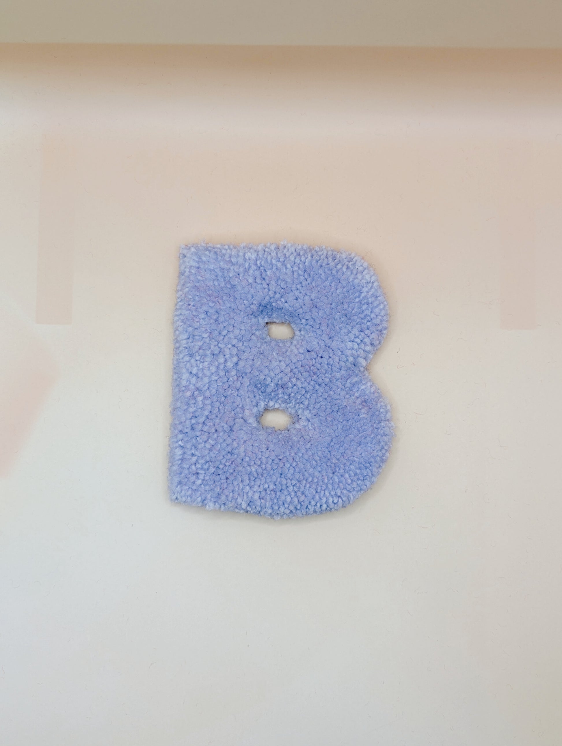 Soft tufted purple letter B with metal hook for easy hanging
