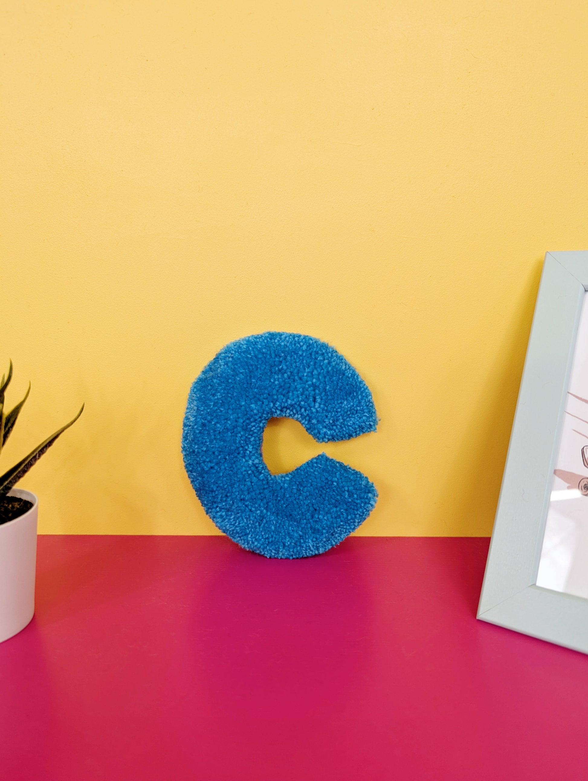 Soft tufted blue letter C with metal hook for easy hanging