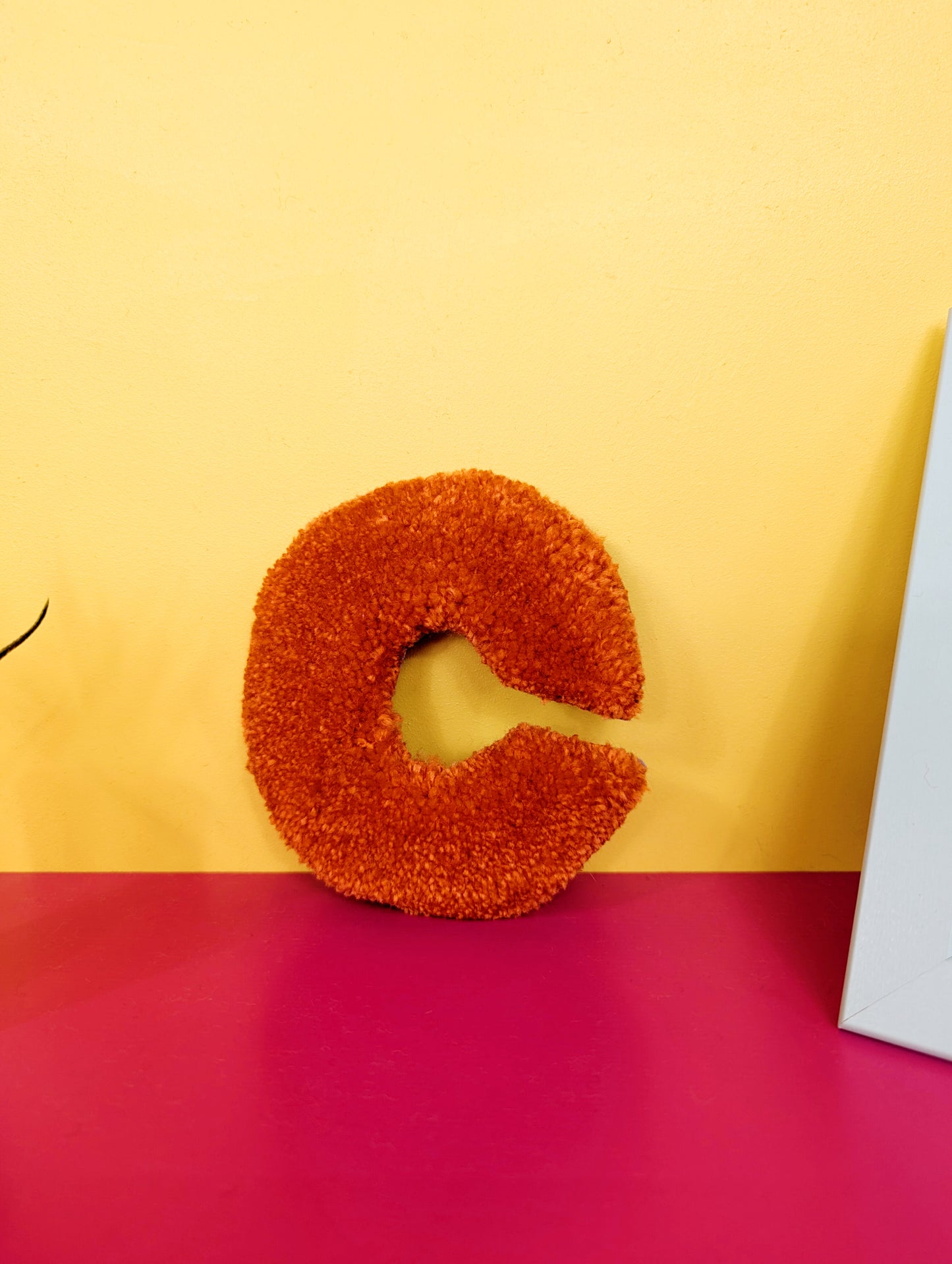 Soft tufted orange letter C with metal hook for easy hanging