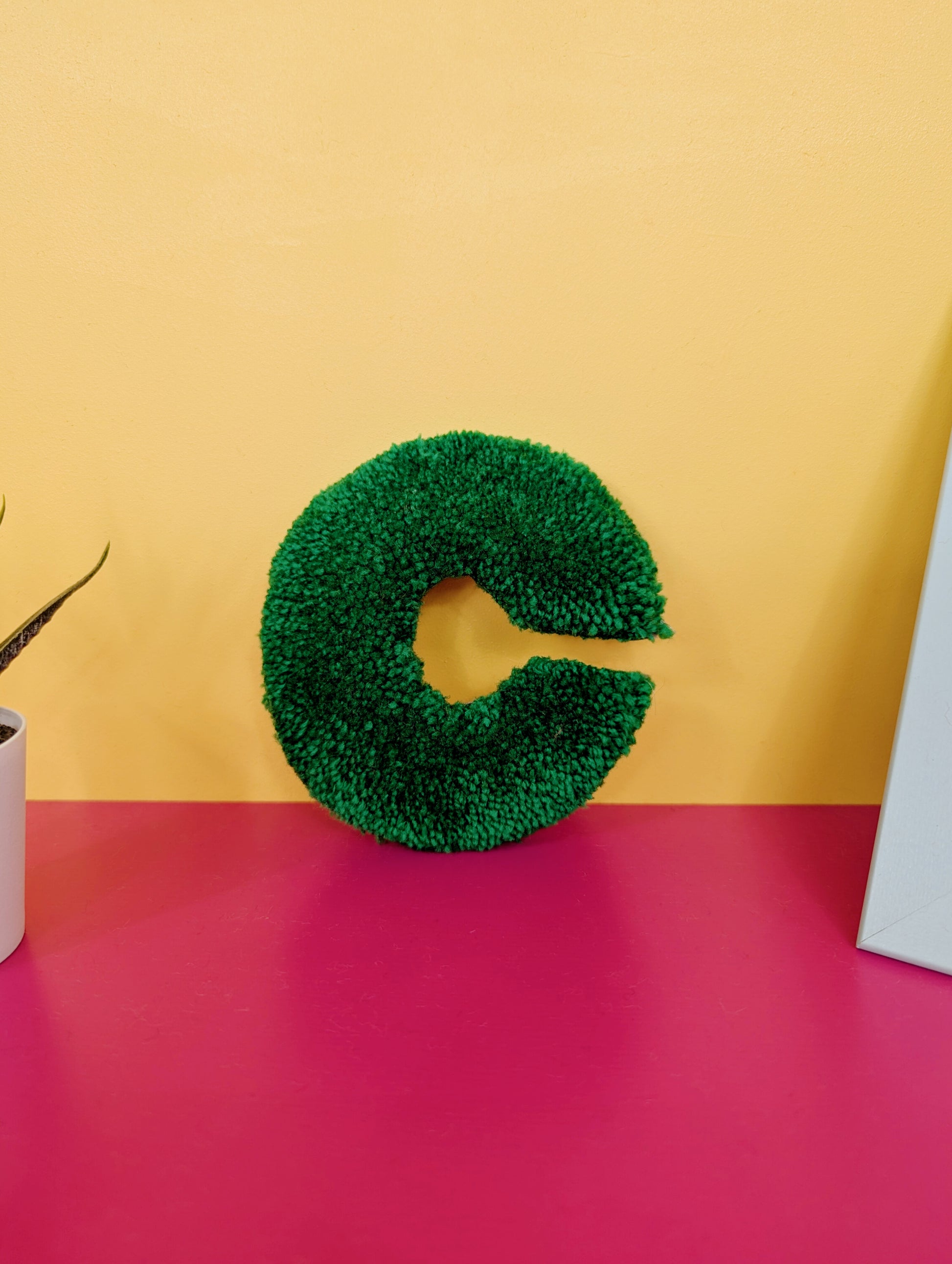 Soft tufted green letter C with metal hook for easy hanging