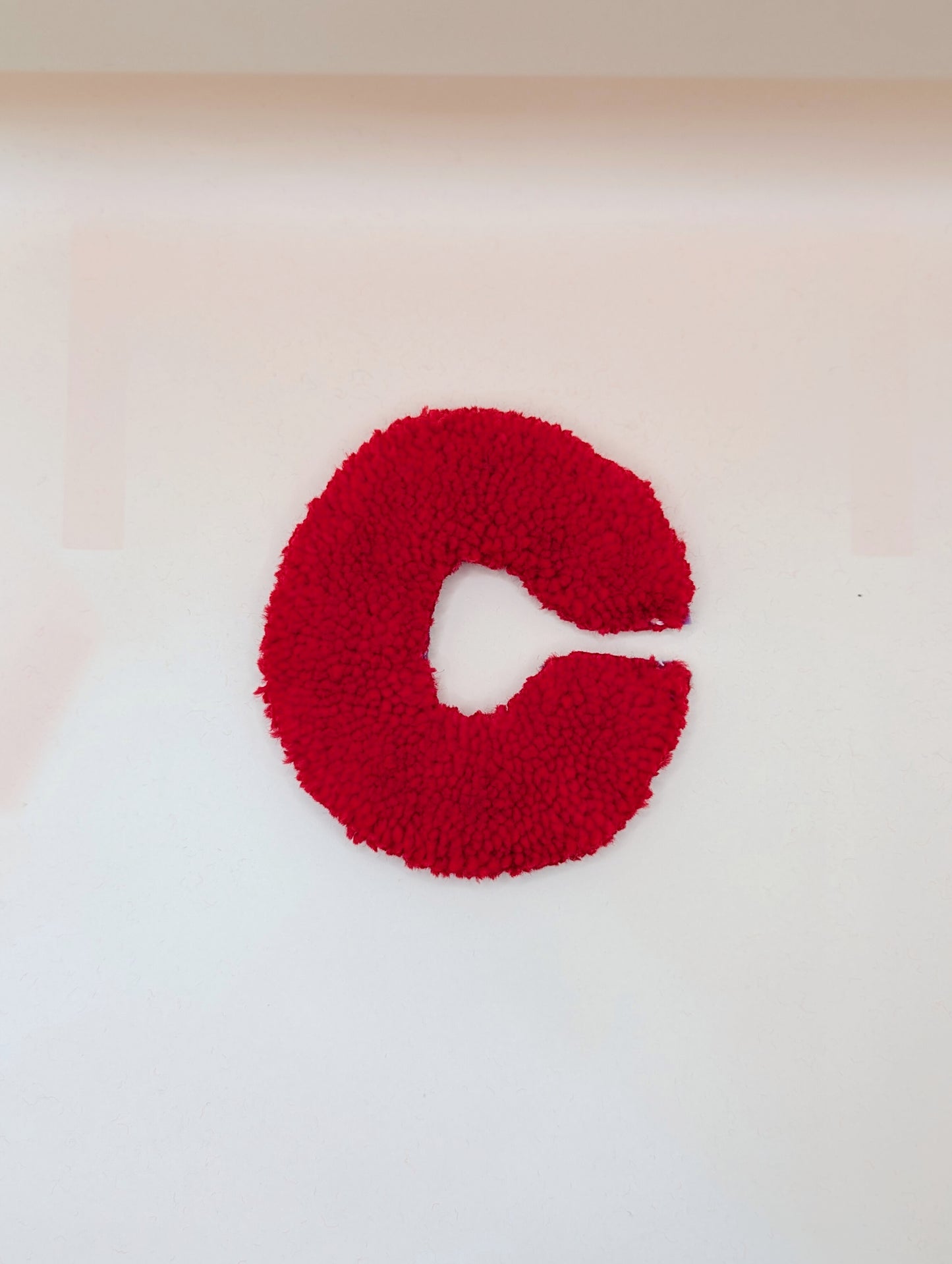 Soft tufted red letter C with metal hook for easy hanging