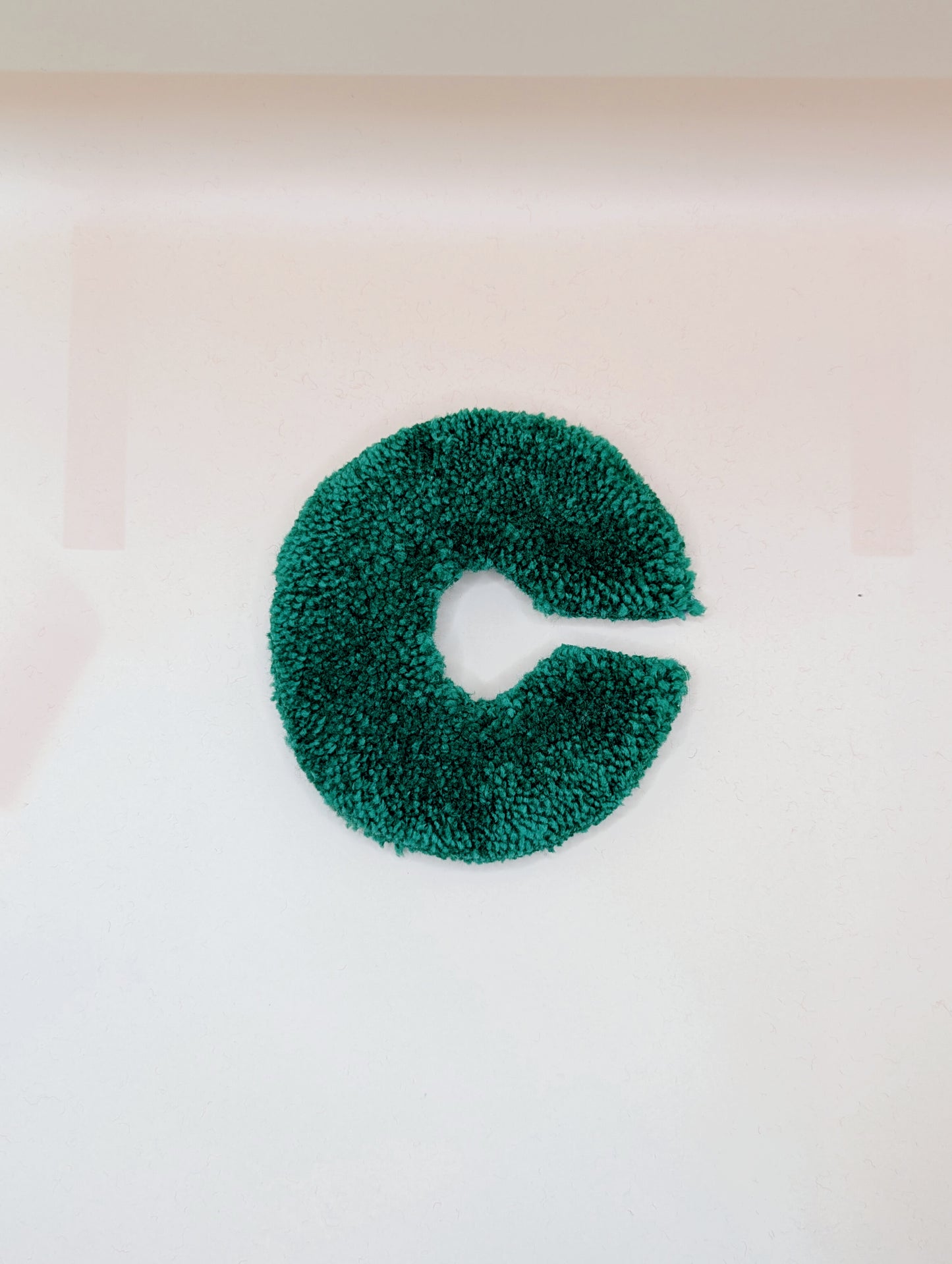 Soft tufted green letter C with metal hook for easy hanging
