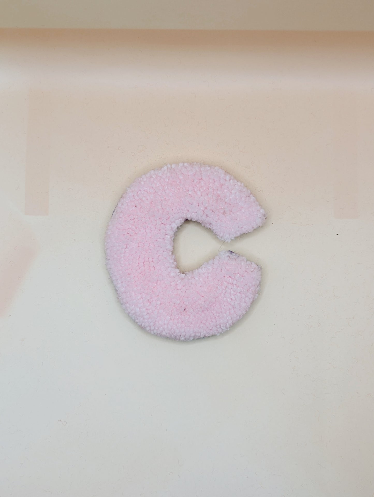 Soft tufted pink letter C with metal hook for easy hanging