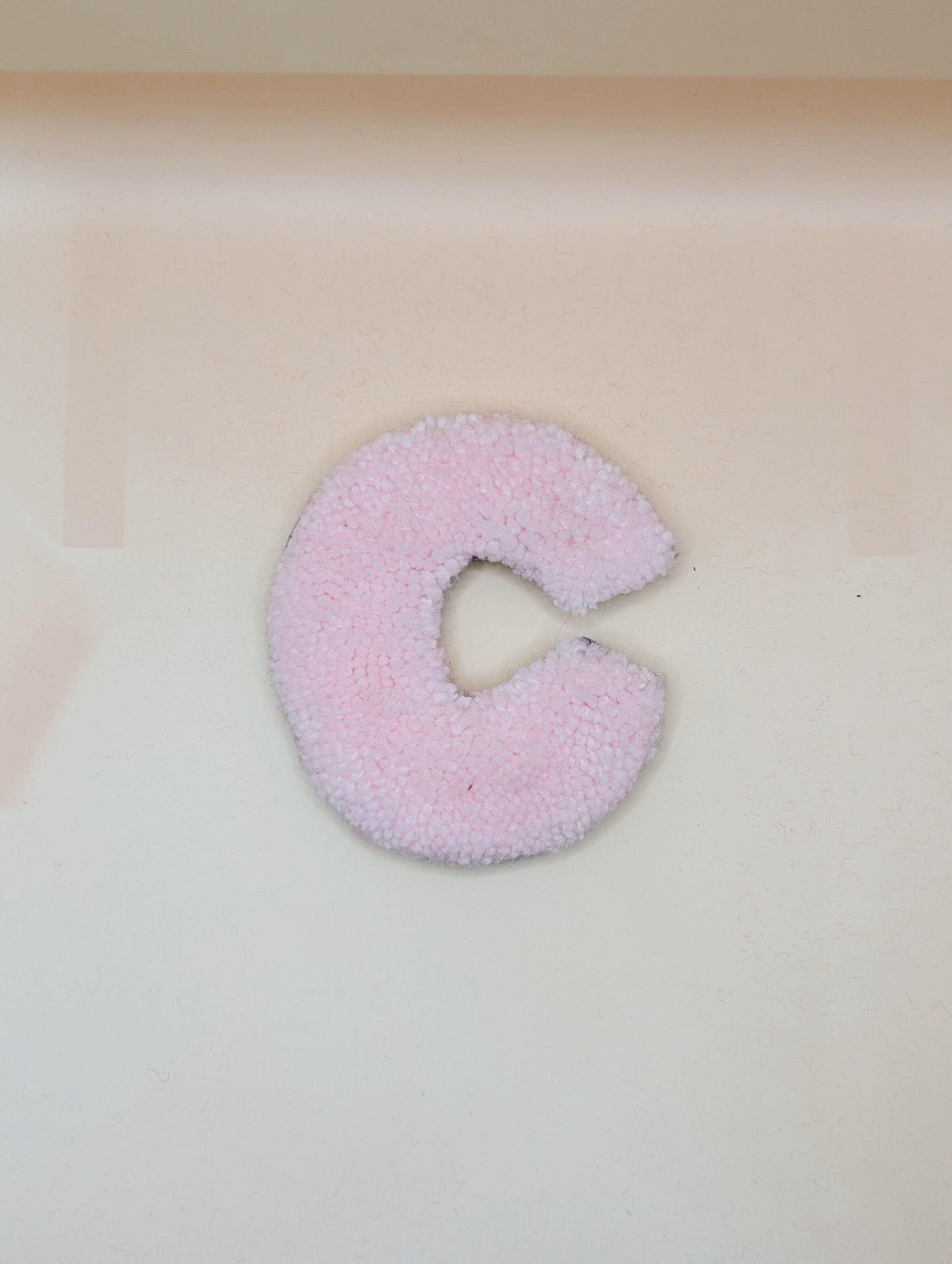 Soft tufted pink letter C with metal hook for easy hanging