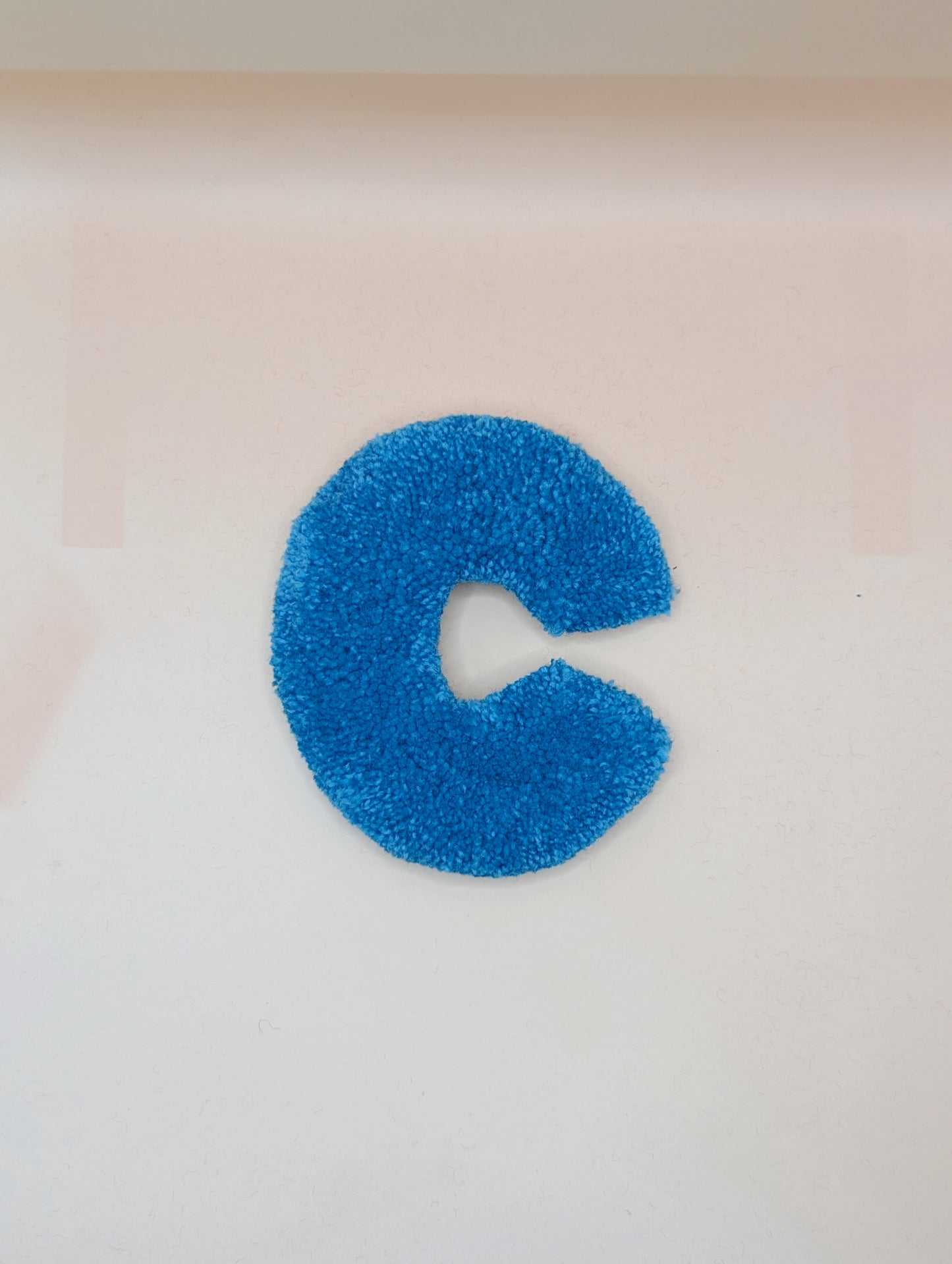 Soft tufted blue letter C with metal hook for easy hanging