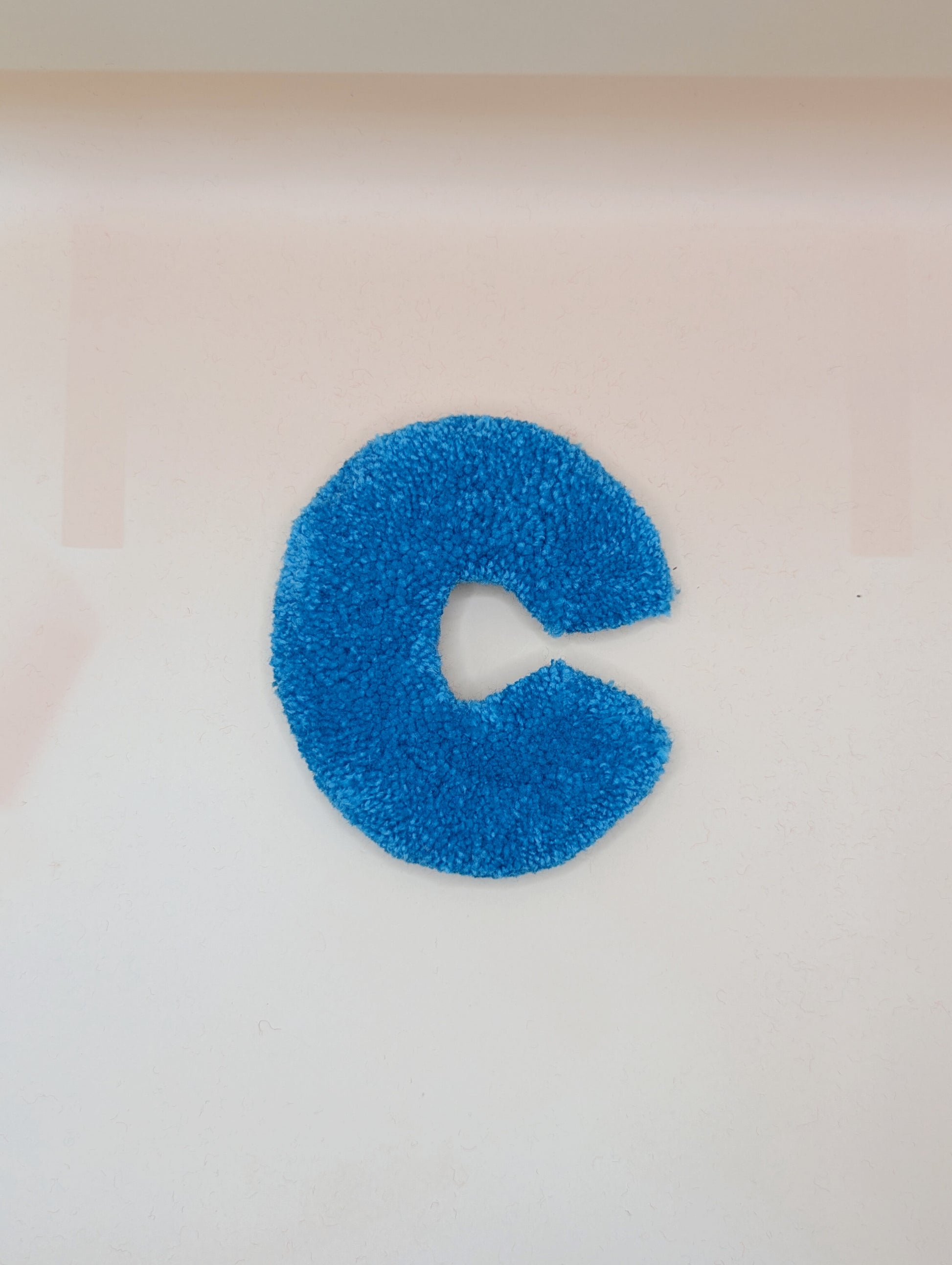 Soft tufted blue letter C with metal hook for easy hanging