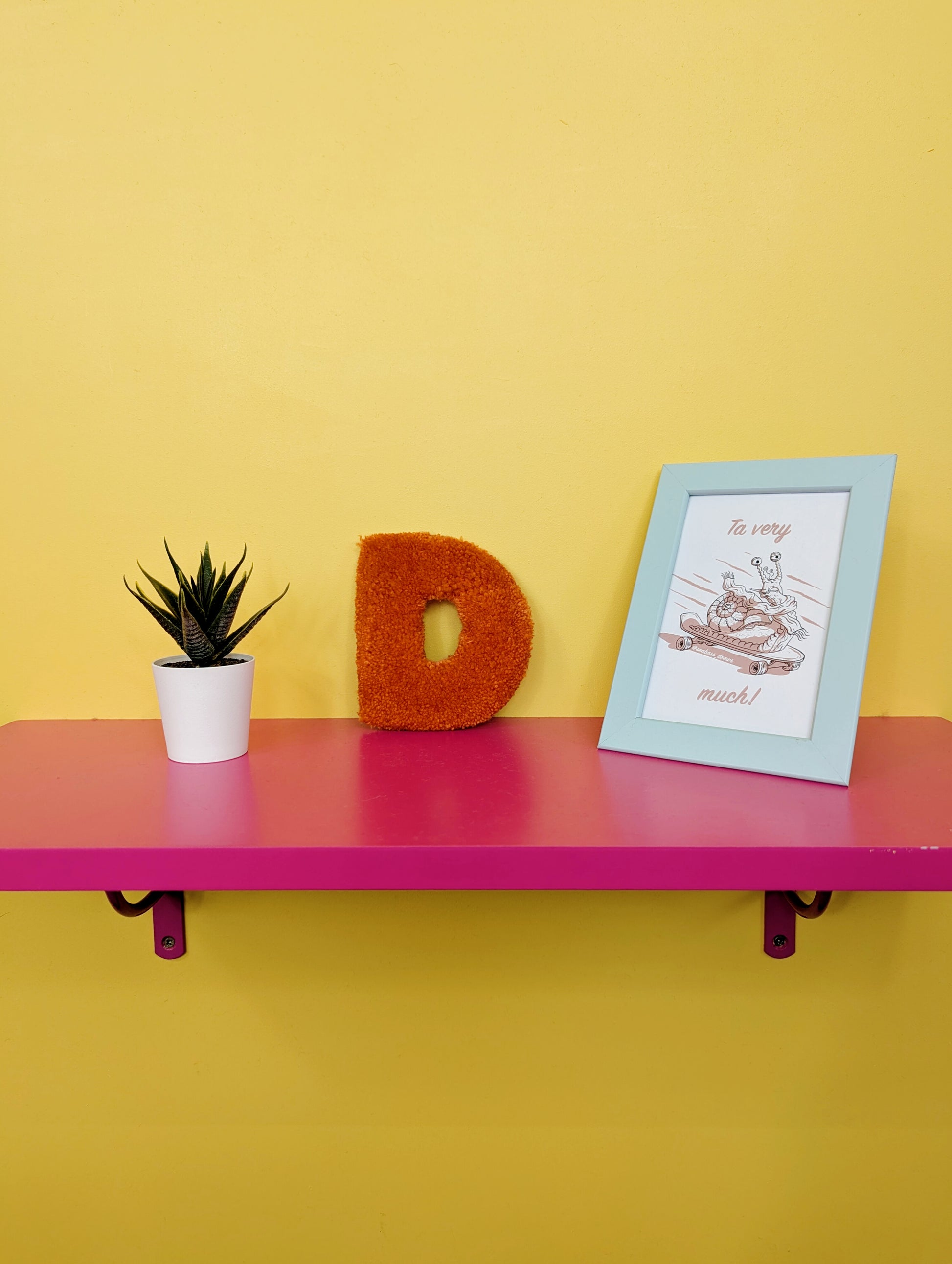 Soft tufted orange letter D with metal hook for easy hanging