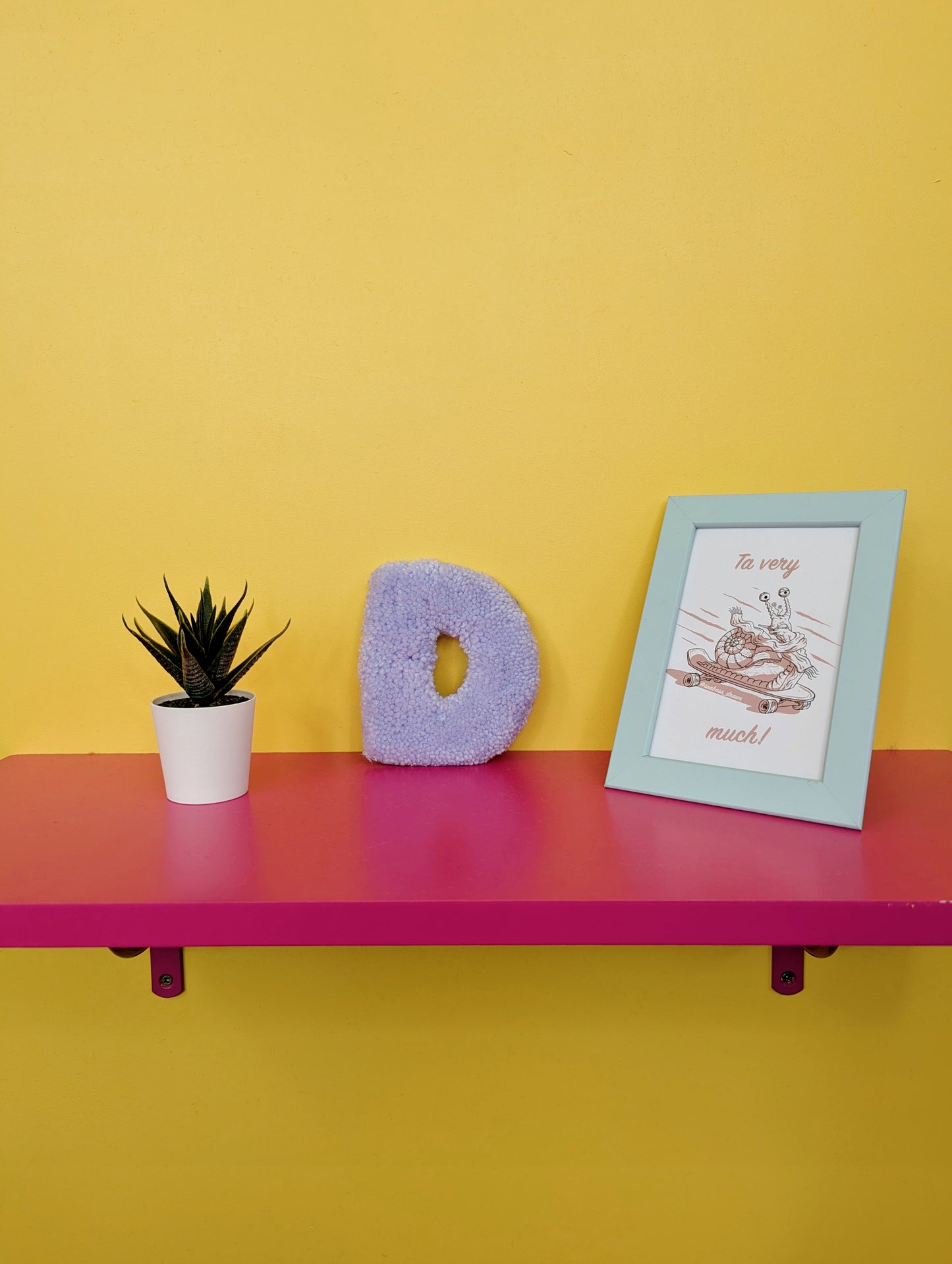 Soft tufted purple letter D with metal hook for easy hanging