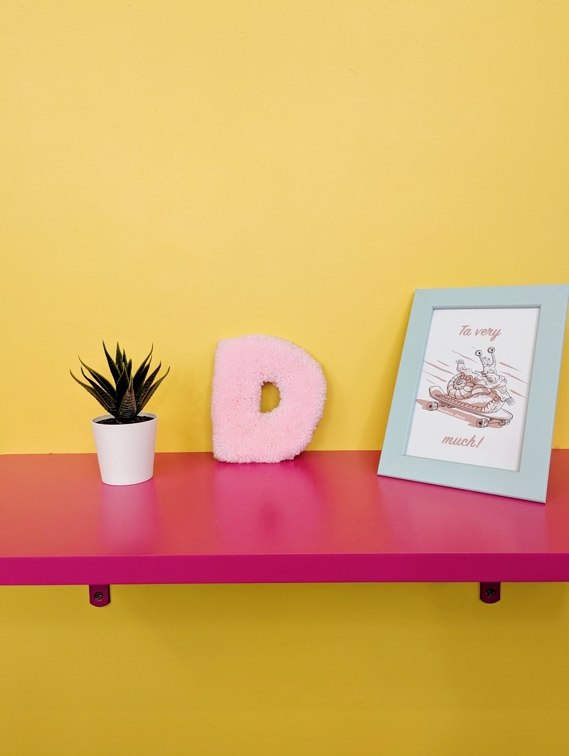 Soft tufted pink letter D with metal hook for easy hanging