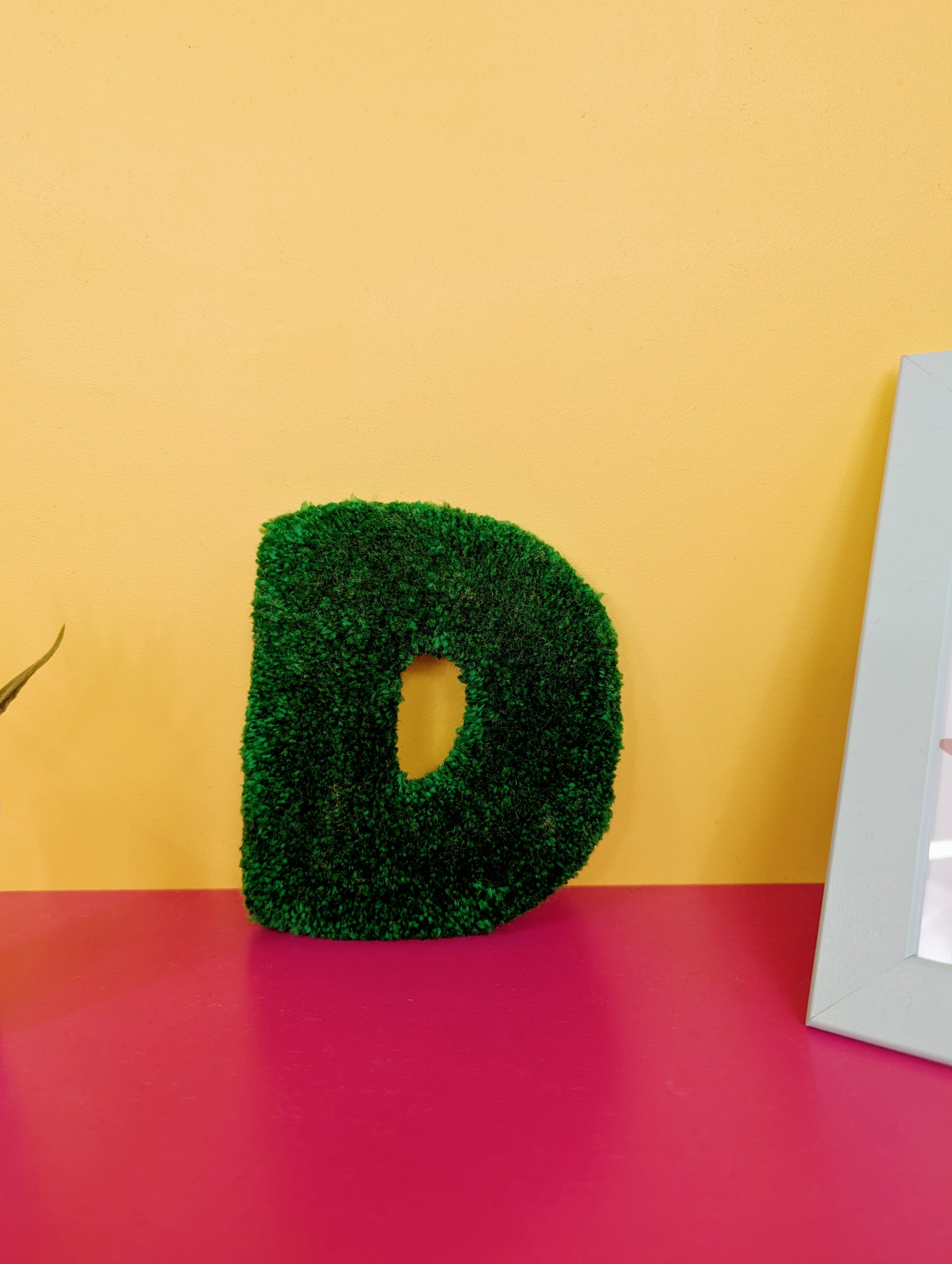 Soft tufted green letter D with metal hook for easy hanging