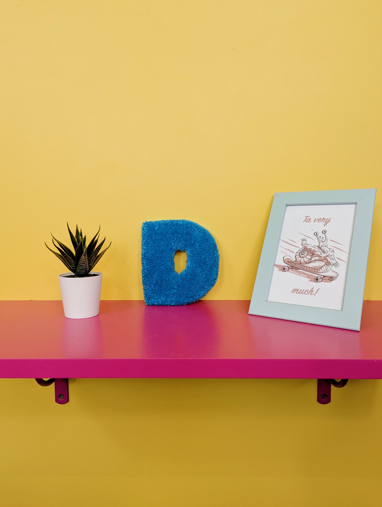 Soft tufted blue letter D with metal hook for easy hanging