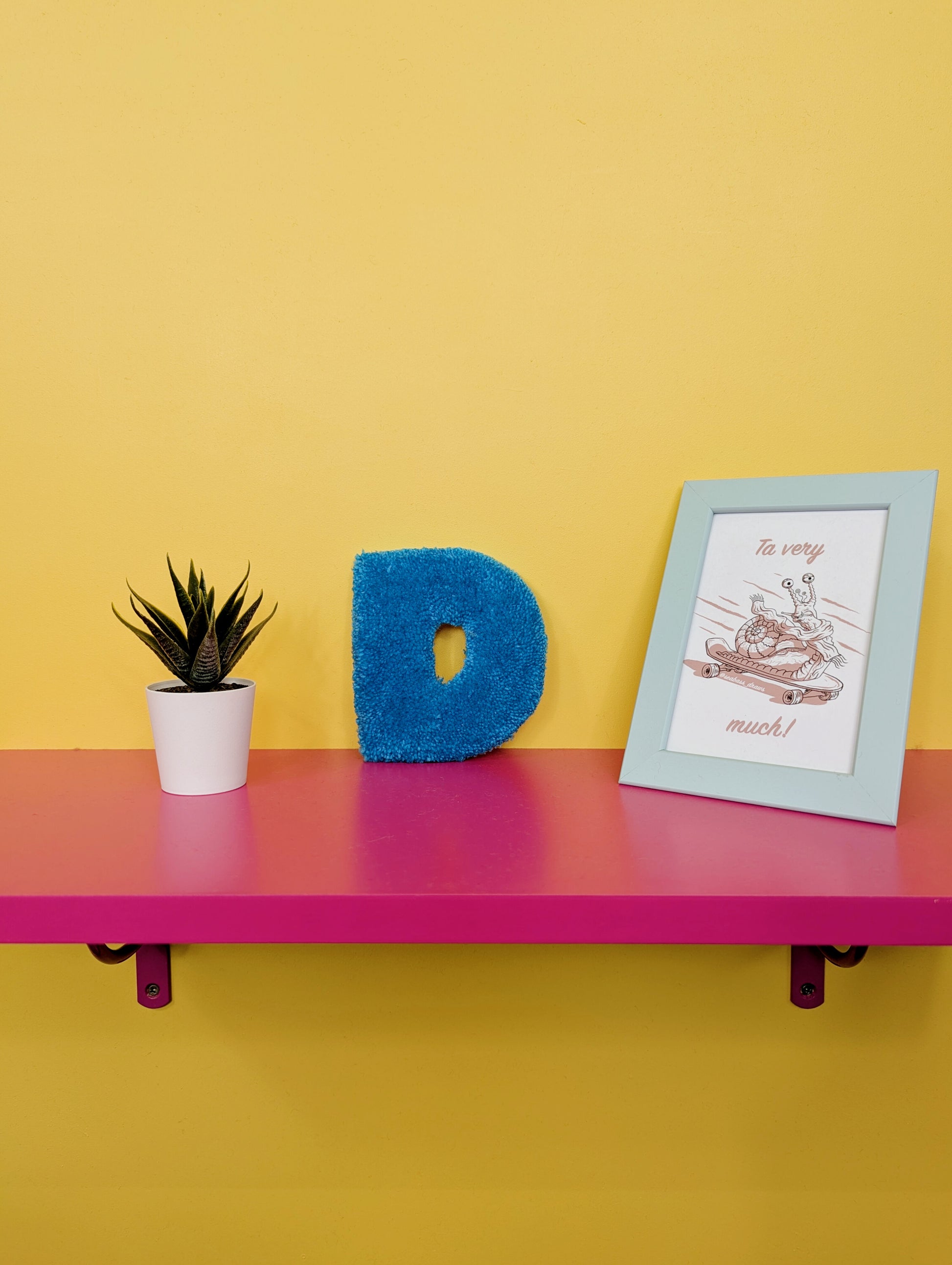 Soft tufted blue letter D with metal hook for easy hanging