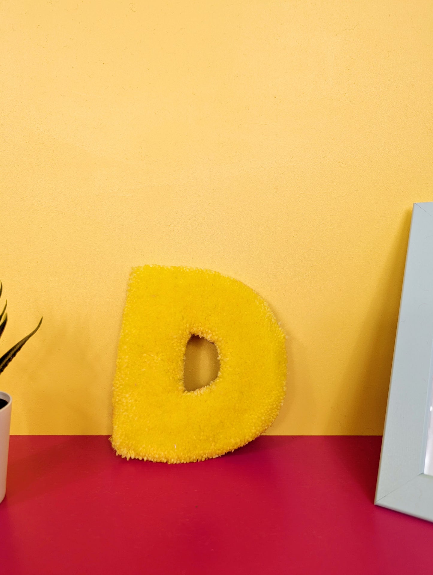Soft tufted yellow letter D with metal hook for easy hanging