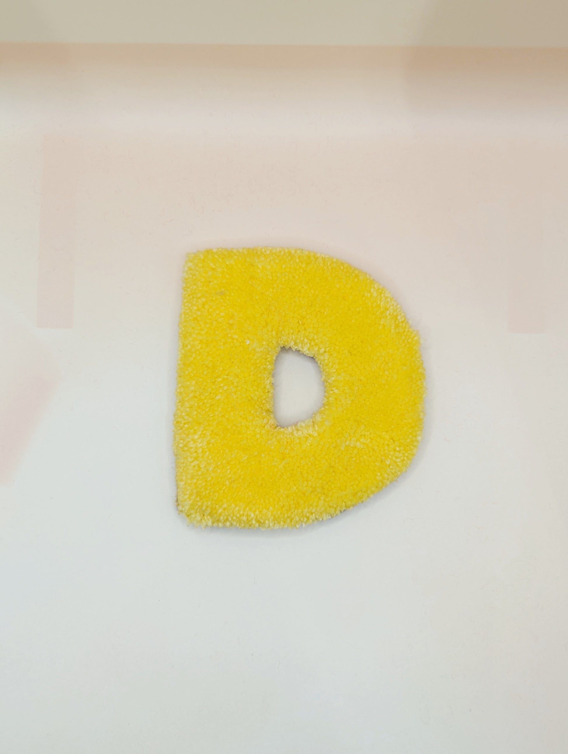 Soft tufted yellow letter D with metal hook for easy hanging