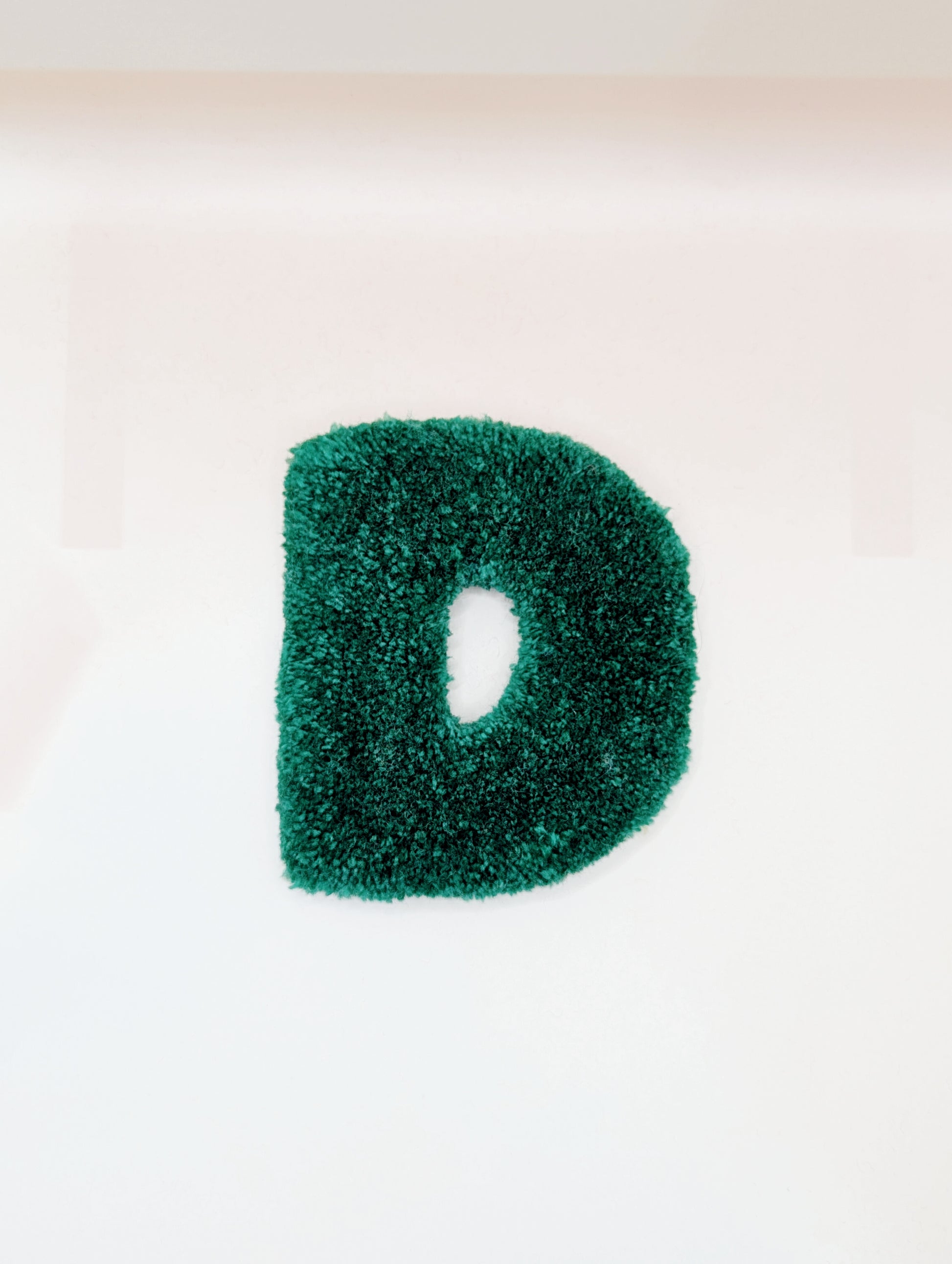 Soft tufted green letter D with metal hook for easy hanging