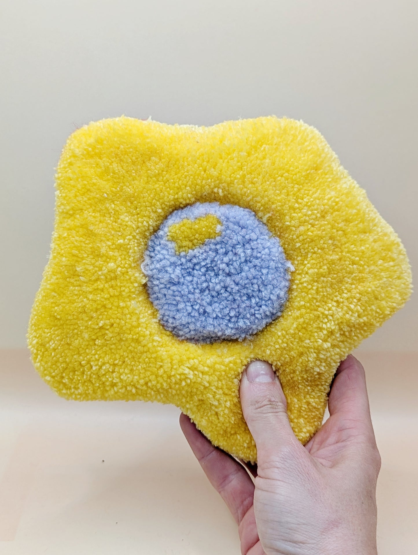 Soft tufted yellow and purple fried egg shaped mini rug/coaster 
