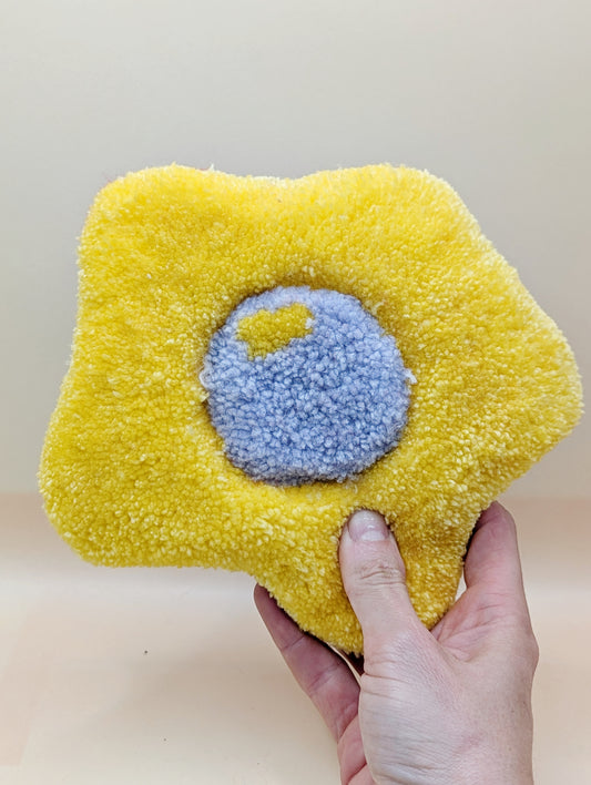 Soft tufted yellow and purple fried egg shaped mini rug/coaster 