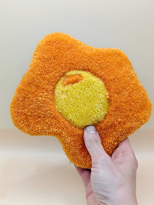 Soft tufted orange and yellow fried egg shaped mini rug/coaster 