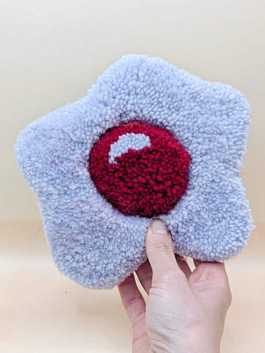 Soft tufted purple and red fried egg shaped mini rug/coaster 