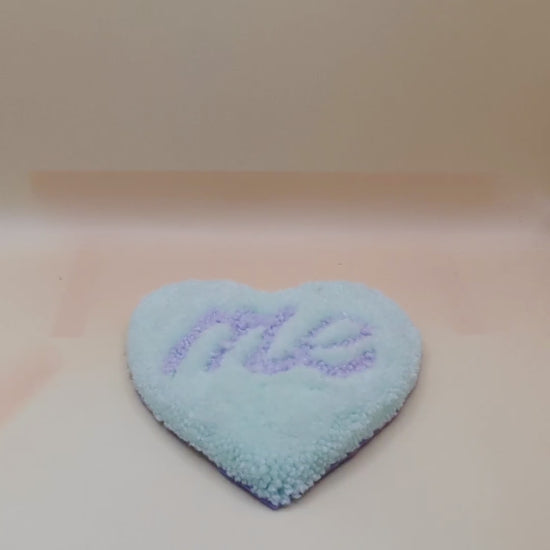 Soft tufted green and purple heart shaped mini rug/coaster with self love slogan
