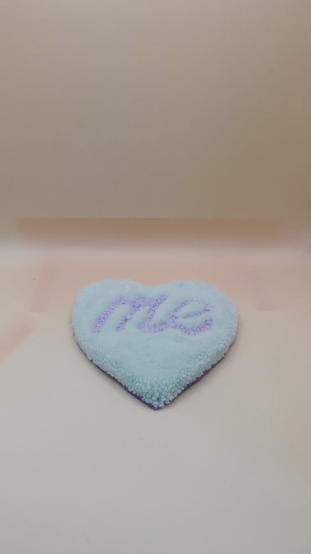 Soft tufted green and purple heart shaped mini rug/coaster with self love slogan