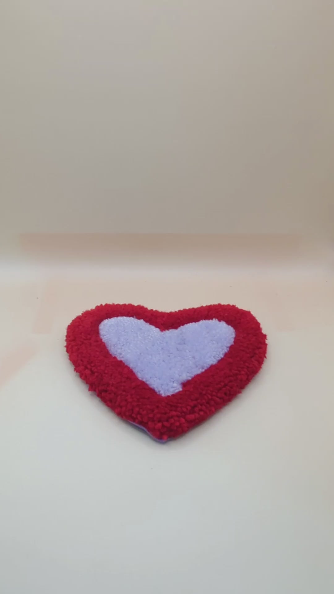 Soft tufted red and purple heart shaped mini rug/coaster 