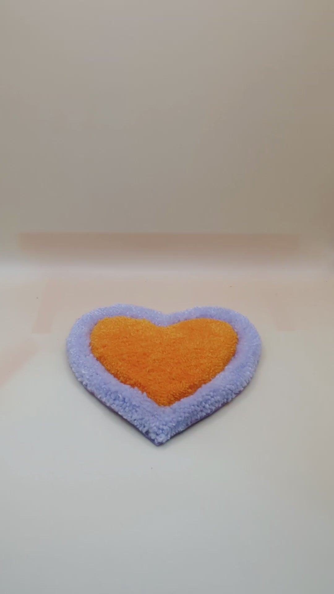 Soft tufted purple and orange heart shaped mini rug/coaster 