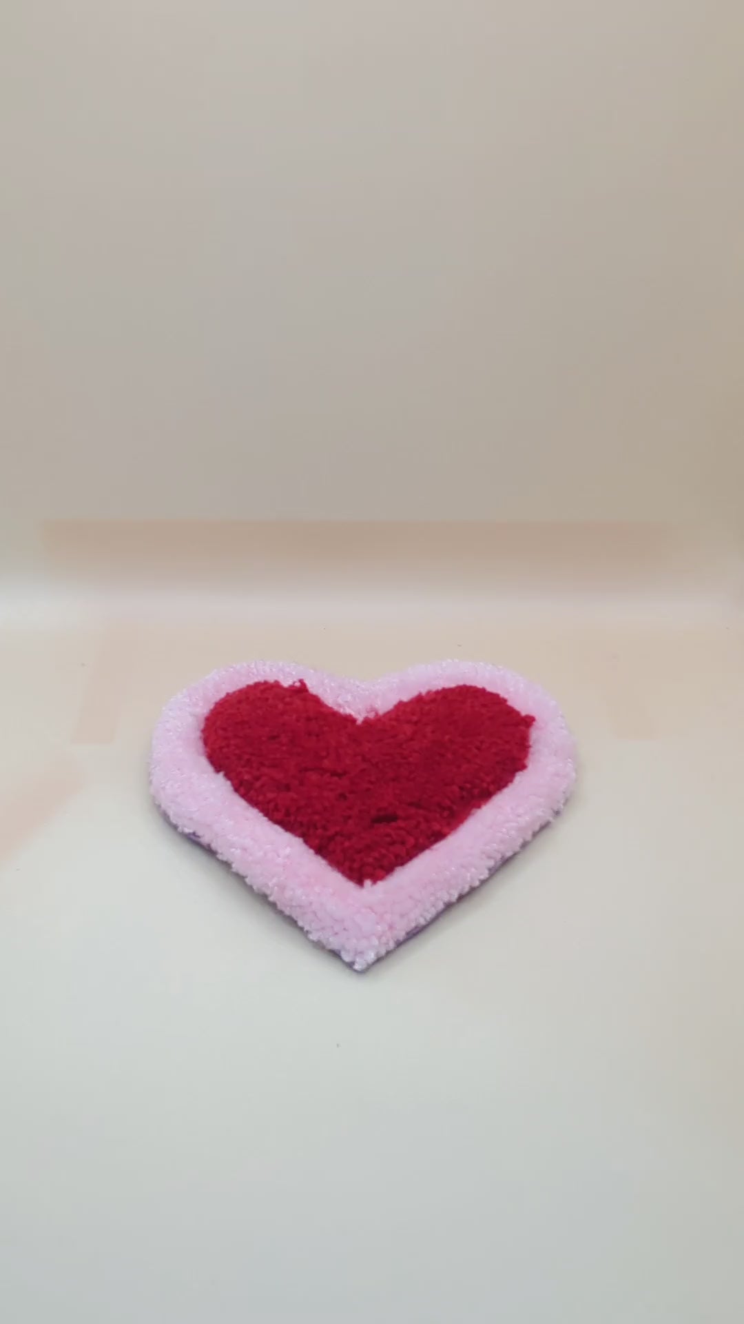 Soft tufted pink and red heart shaped mini rug/coaster 